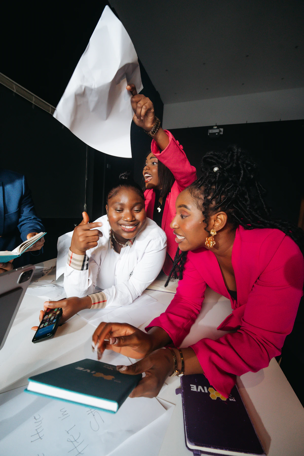 Three women celebrating and holding a white flag