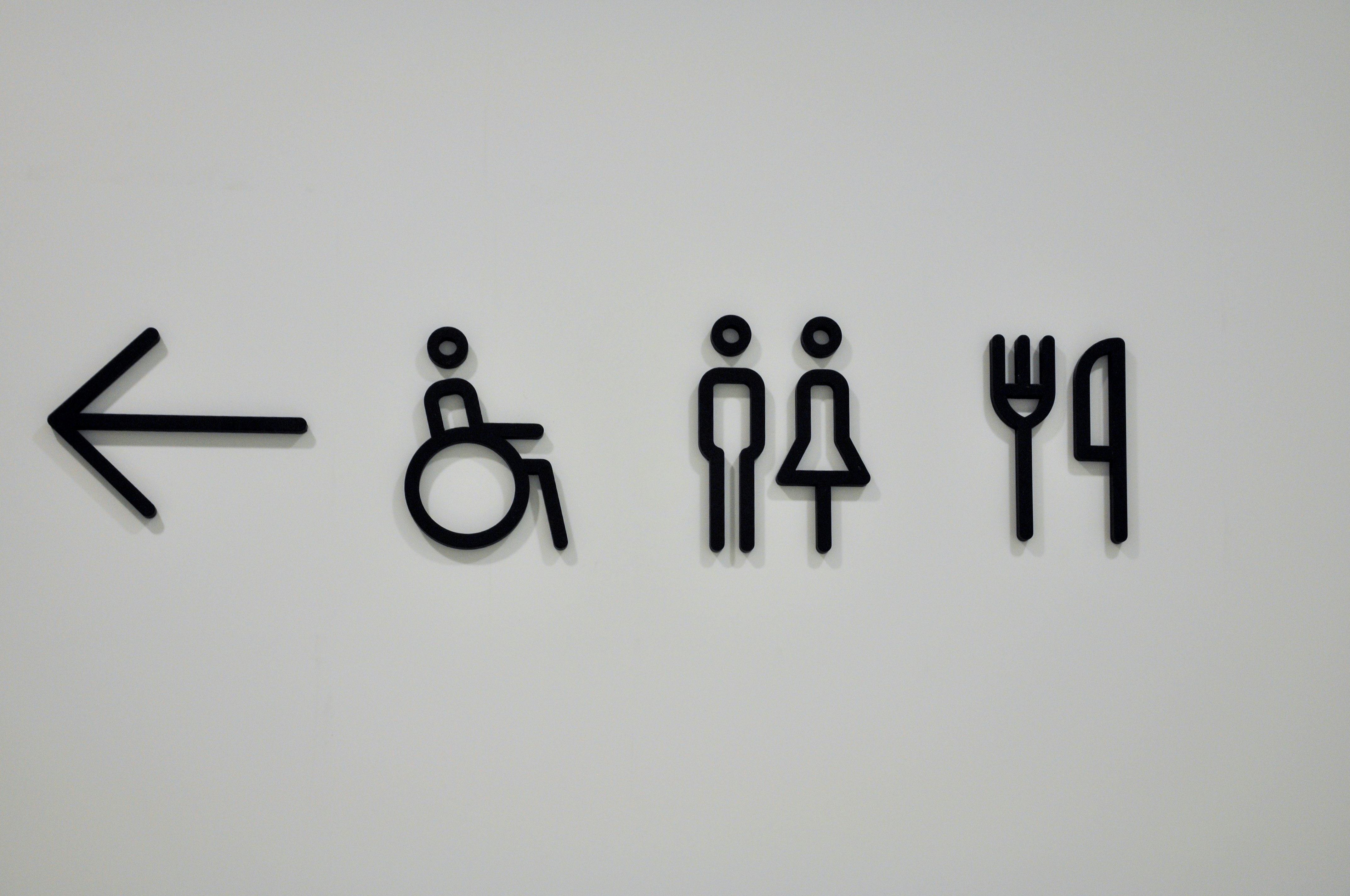 Arrow, wheelchair, restroom, and dining icons on white background