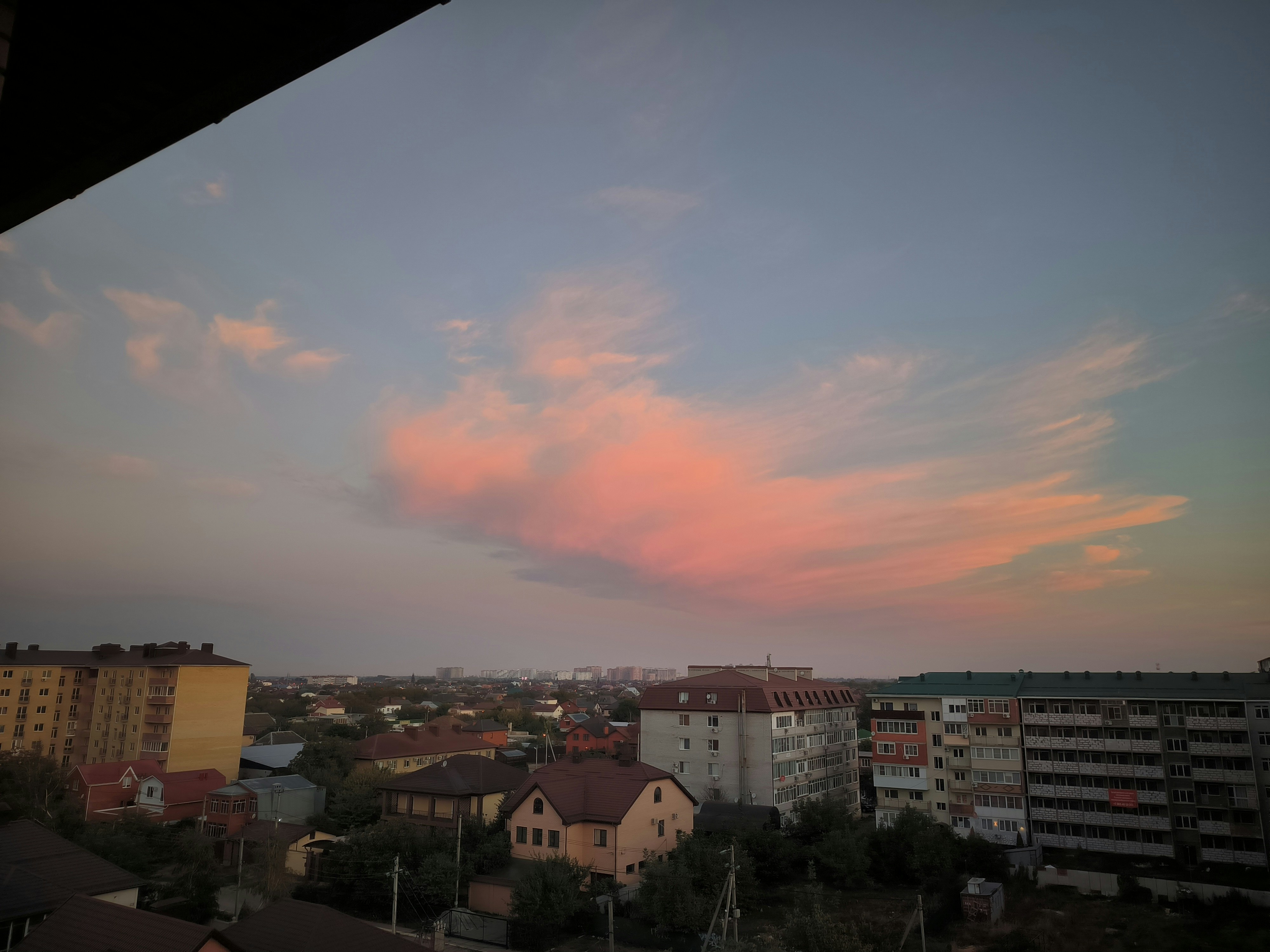 夕暮れの街の上に広がるピンクと青の雲。