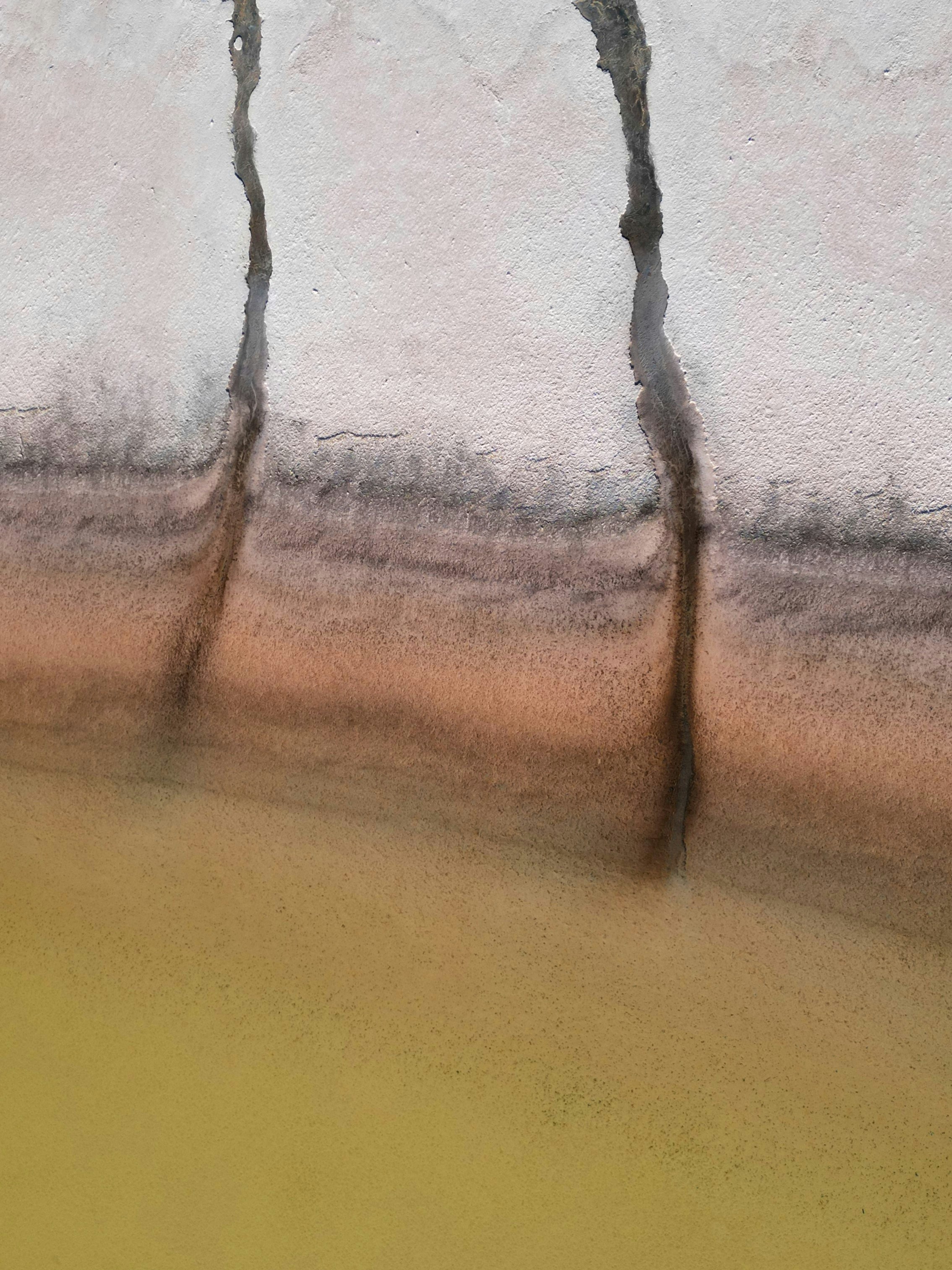 ひび割れた土の質感で、下には黄色い水が流れています