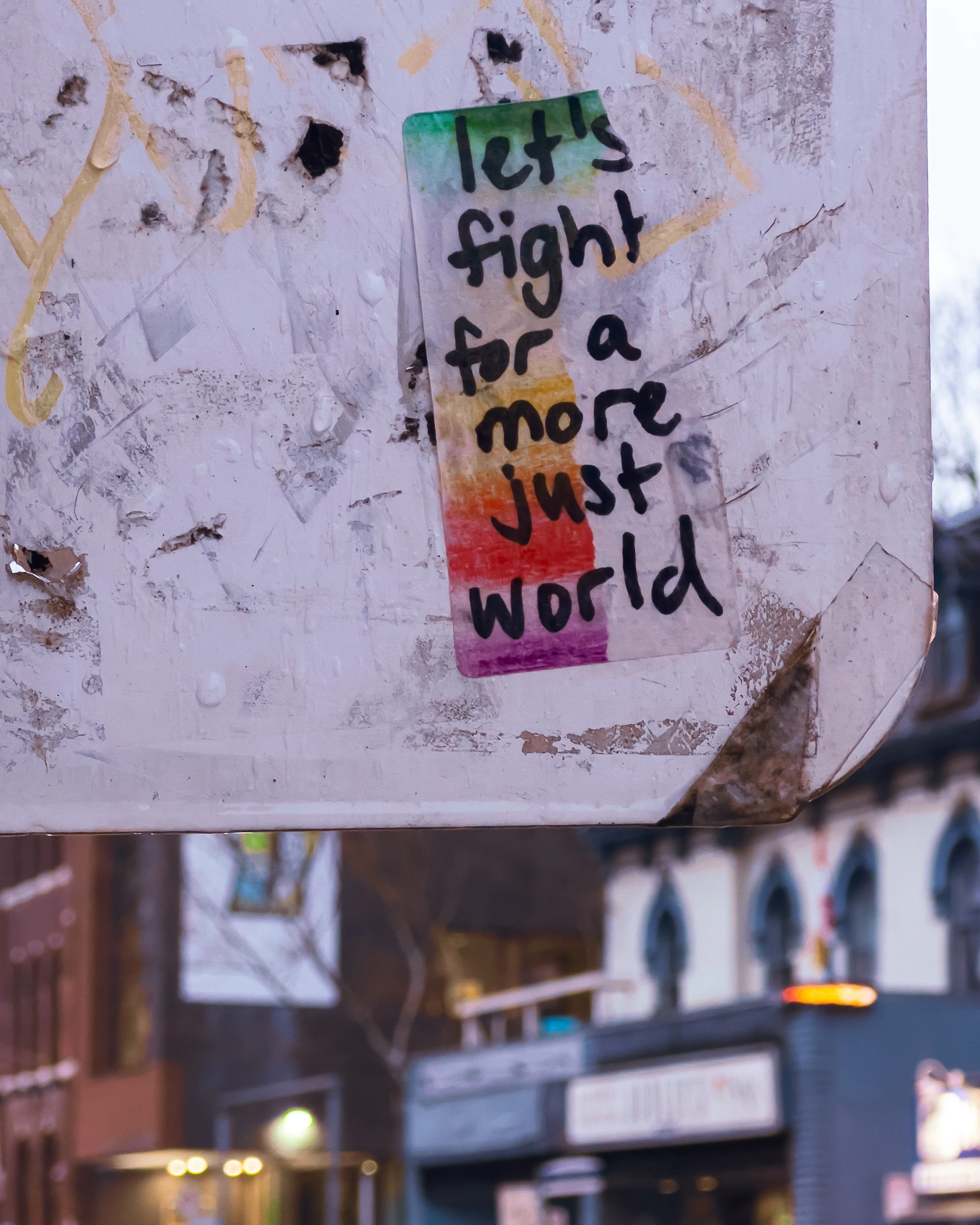 Sticker with rainbow colors and text about a just world.