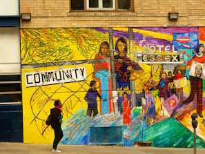 A person walks past a vibrant community mural.