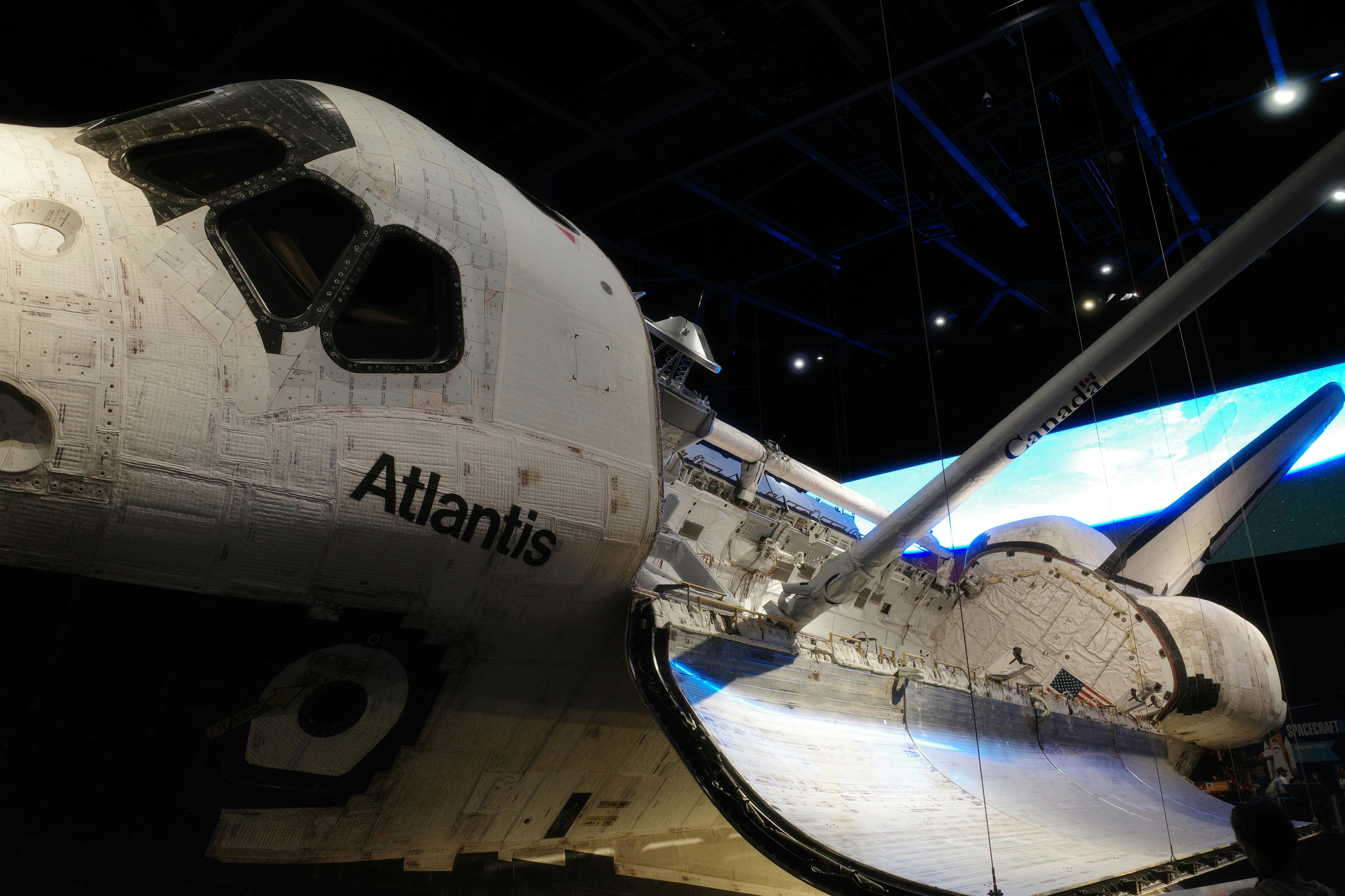 Space shuttle atlantis displayed indoors, showing its fuselage and wing.