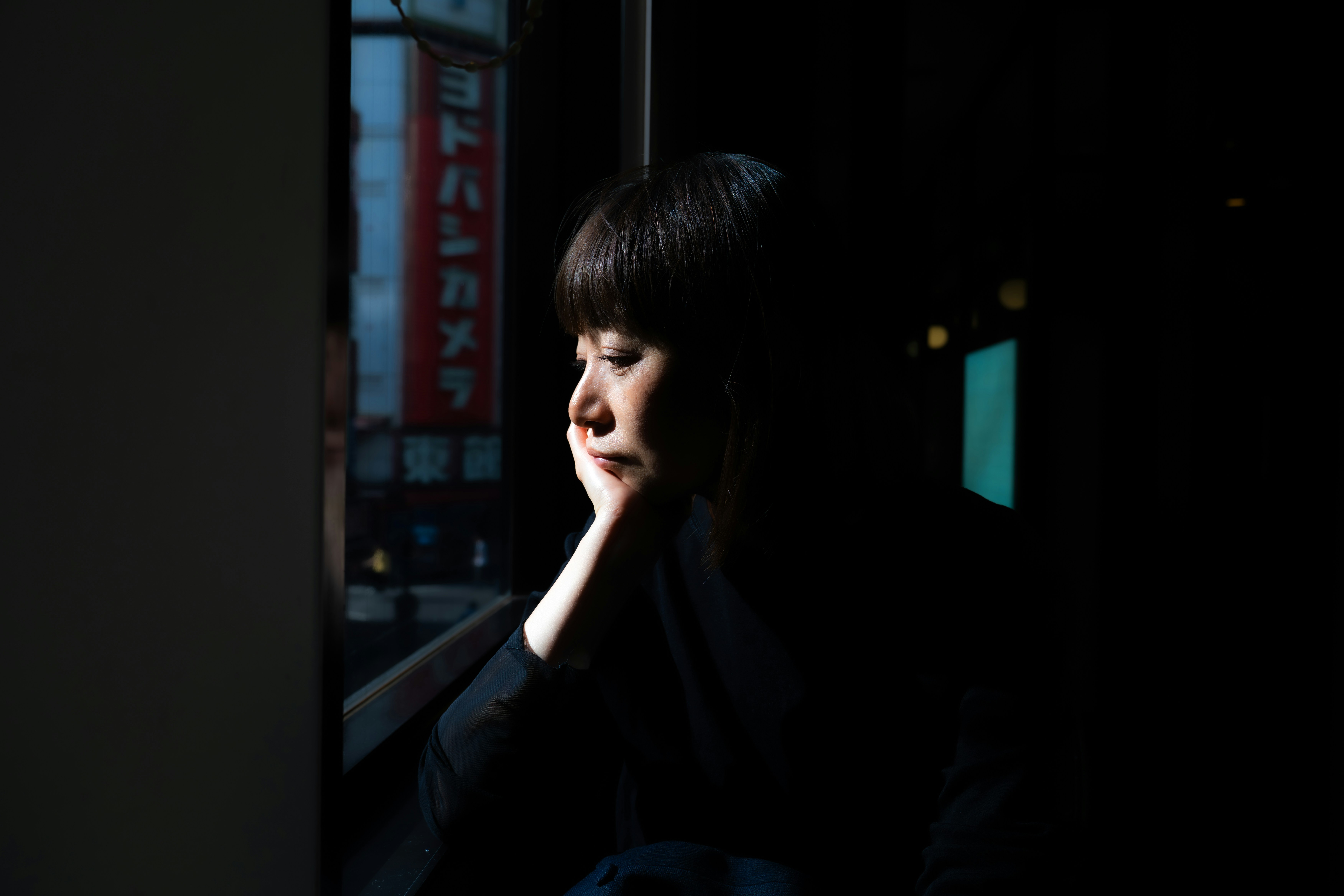 Woman looking out window at night