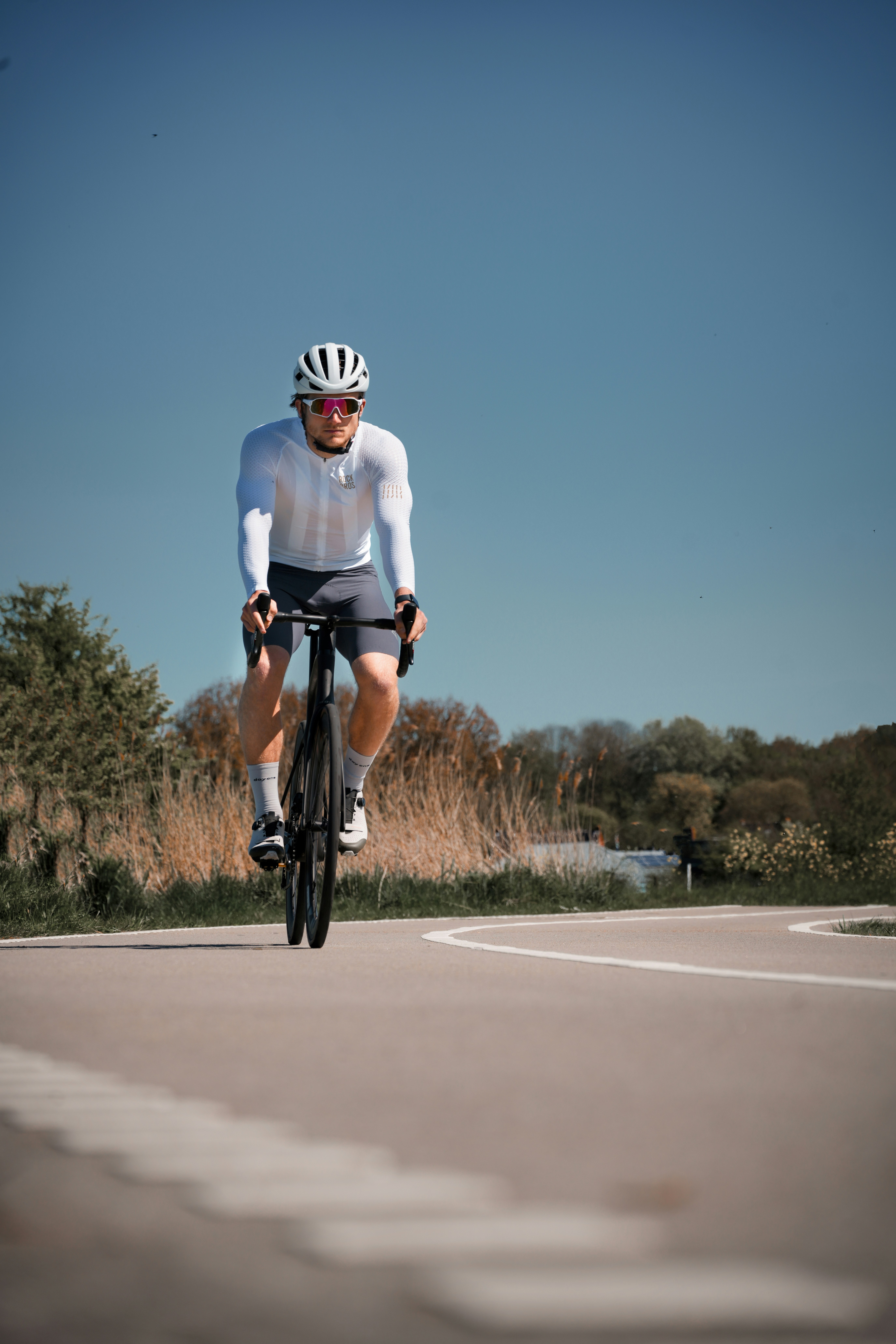 Man cycling on a road with blue sky