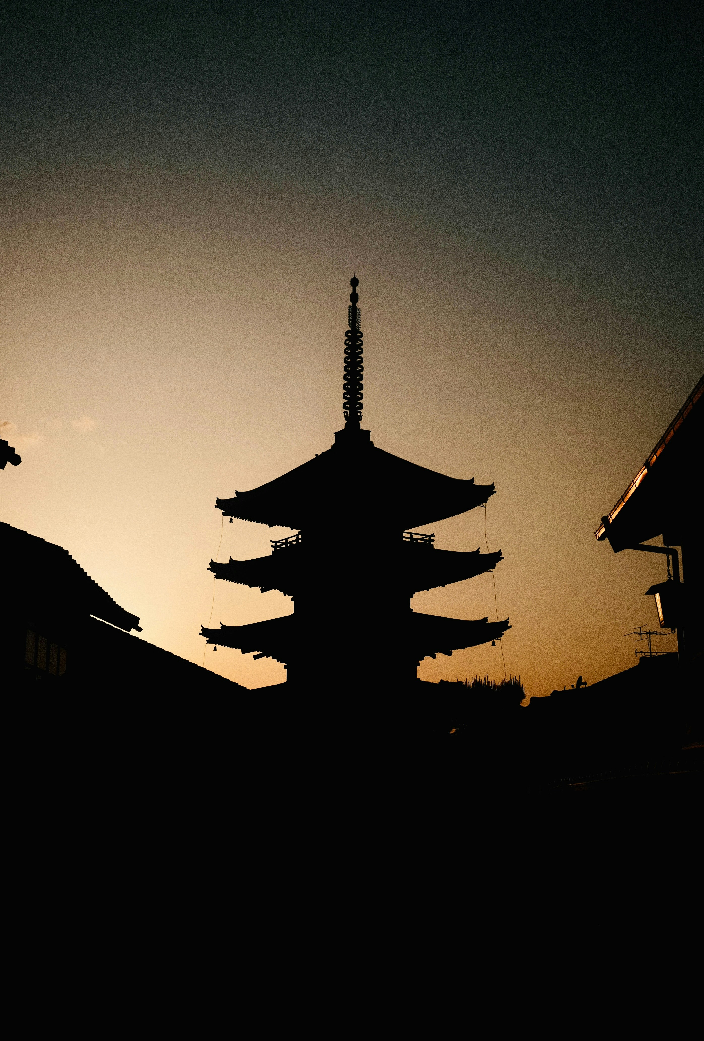 A pagoda in silhouette against a sunset sky.