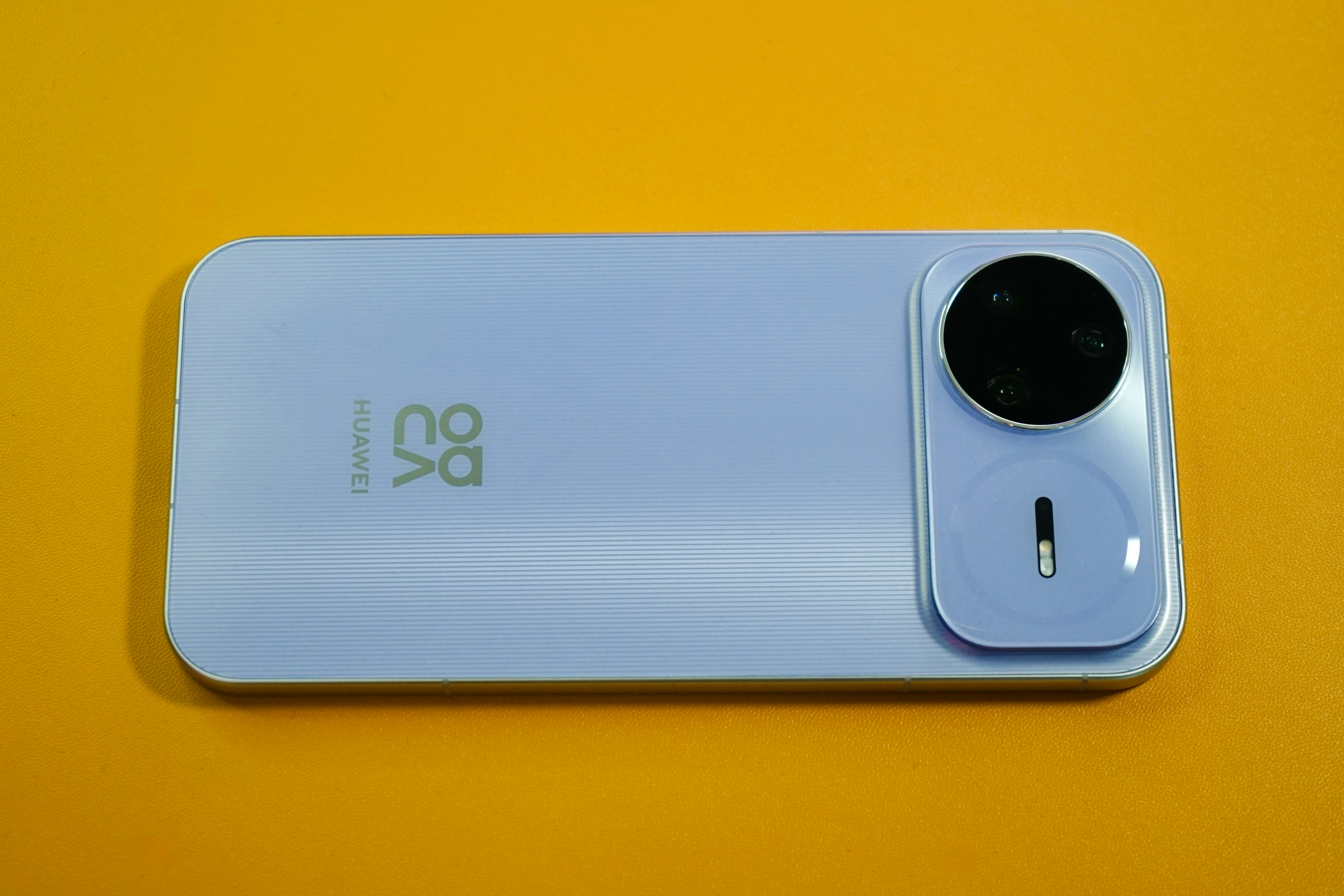 Un smartphone violet clair avec un module caméra circulaire.