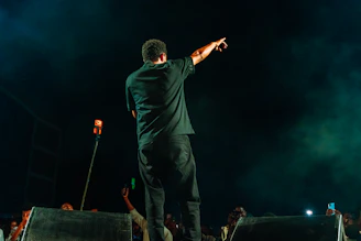 Performer on stage pointing to the crowd at night
