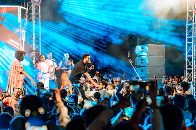 A band performs for a large crowd at a concert.