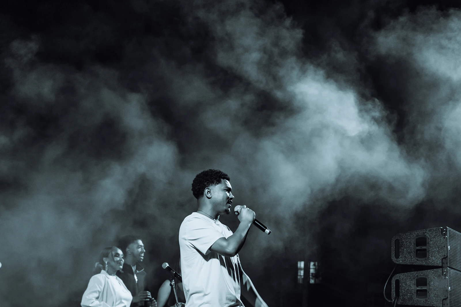 Singer performing on a smoky stage during a music video shoot