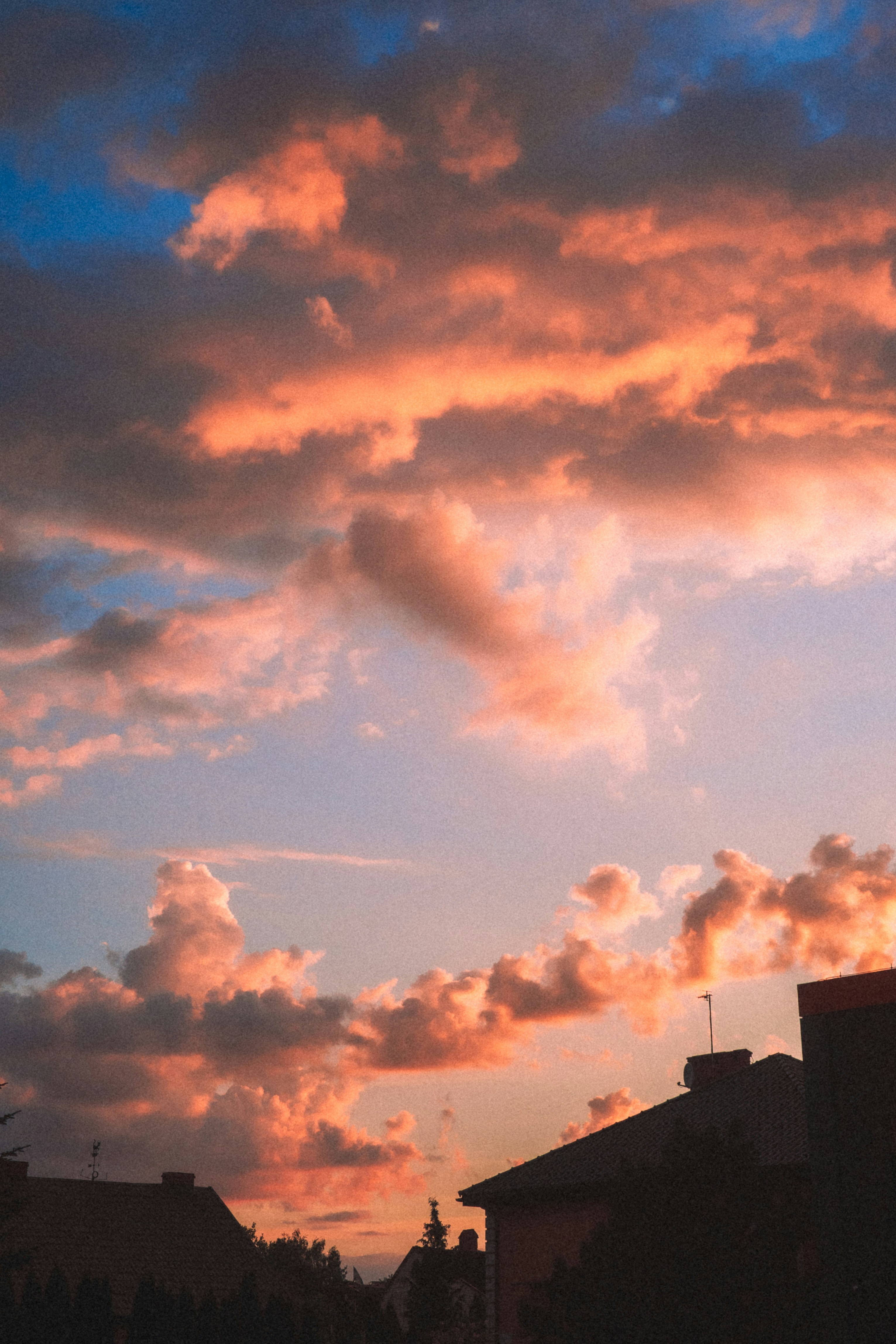 Dramatic sunset clouds over silhouetted rooftops