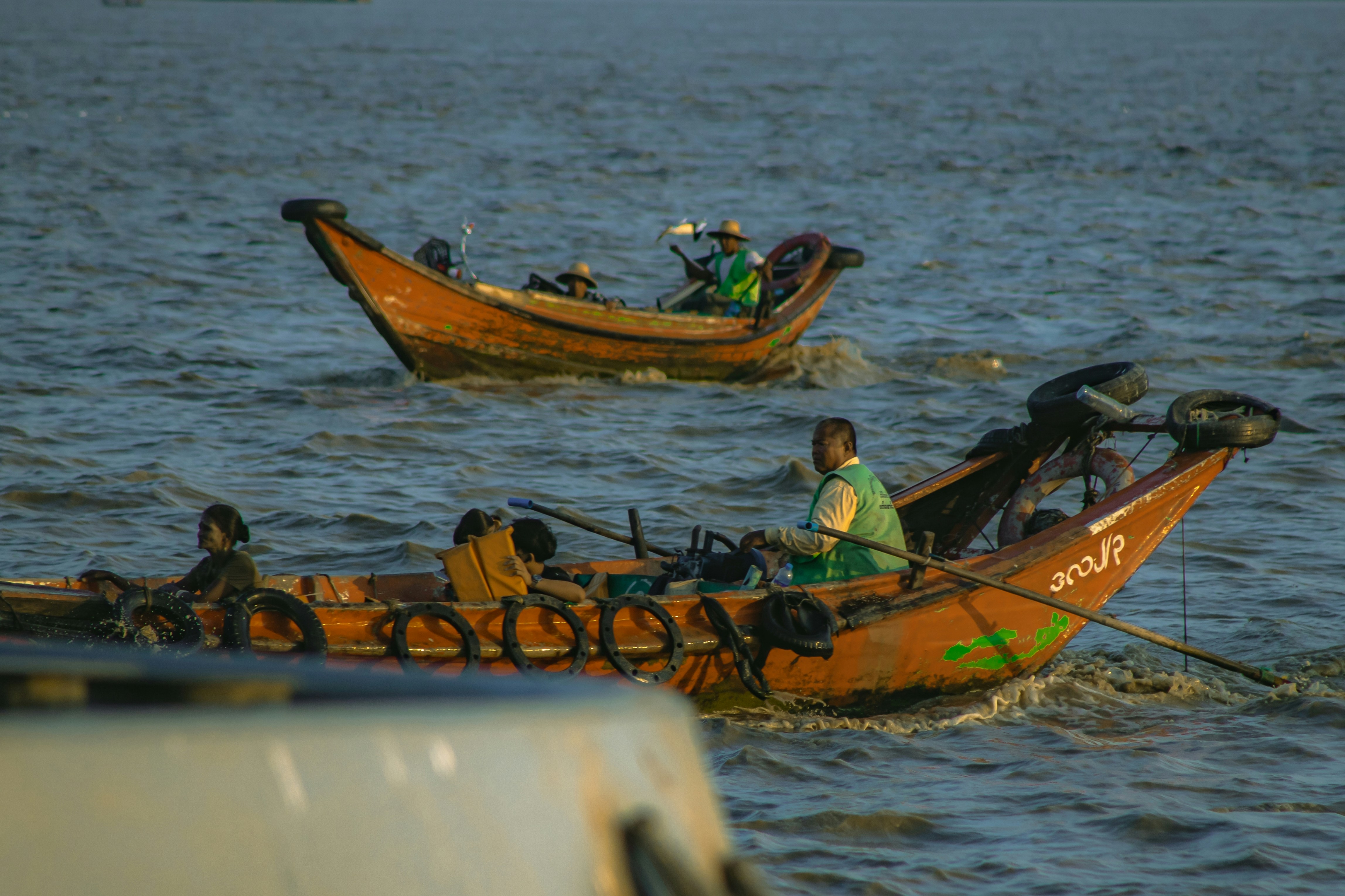 Two fishermen in small boats on the water.