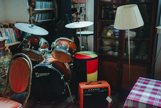 Drum kit, floor lamp, and amplifier in a cozy room