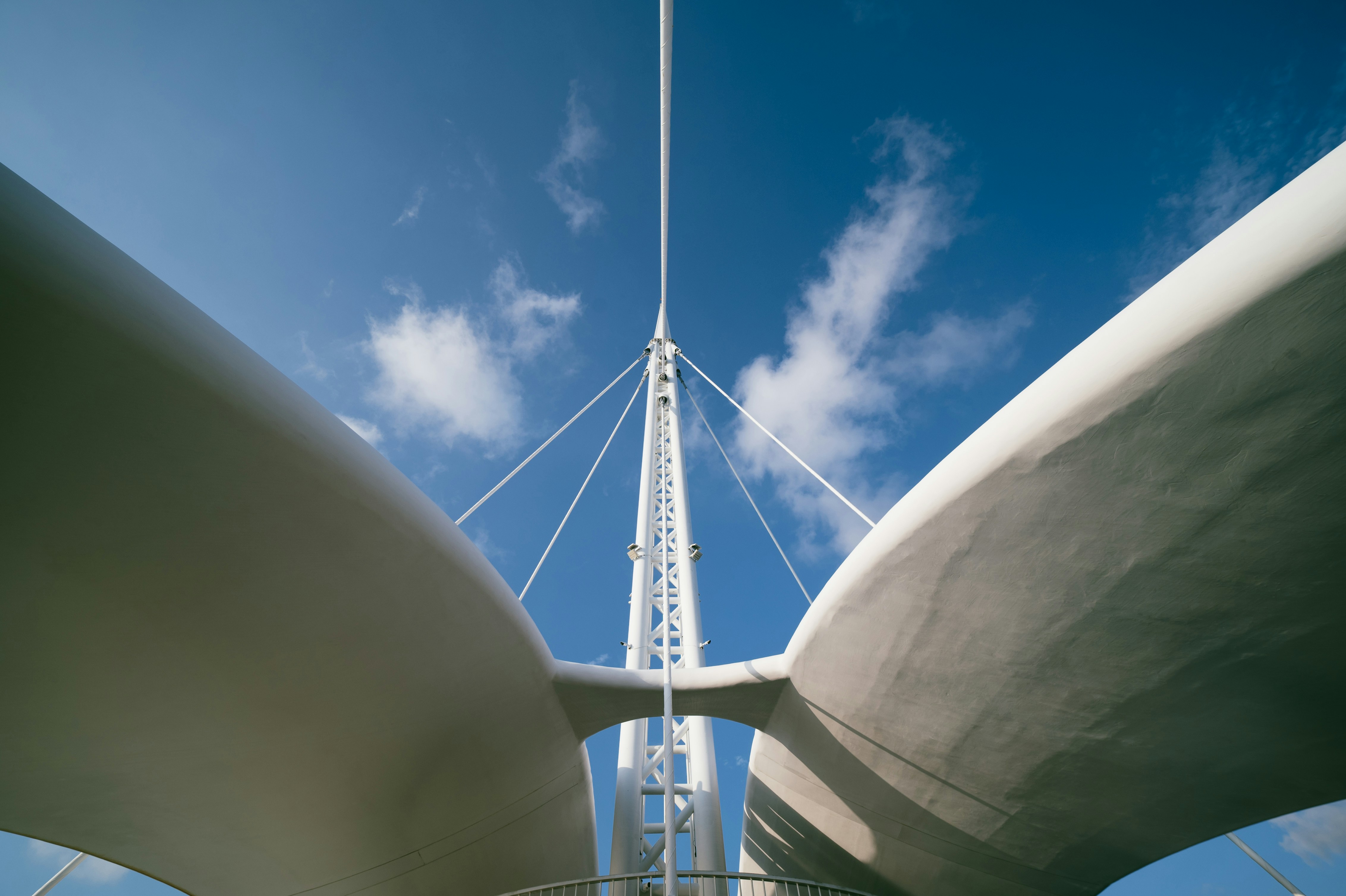 Modern white bridge structure against a blue sky