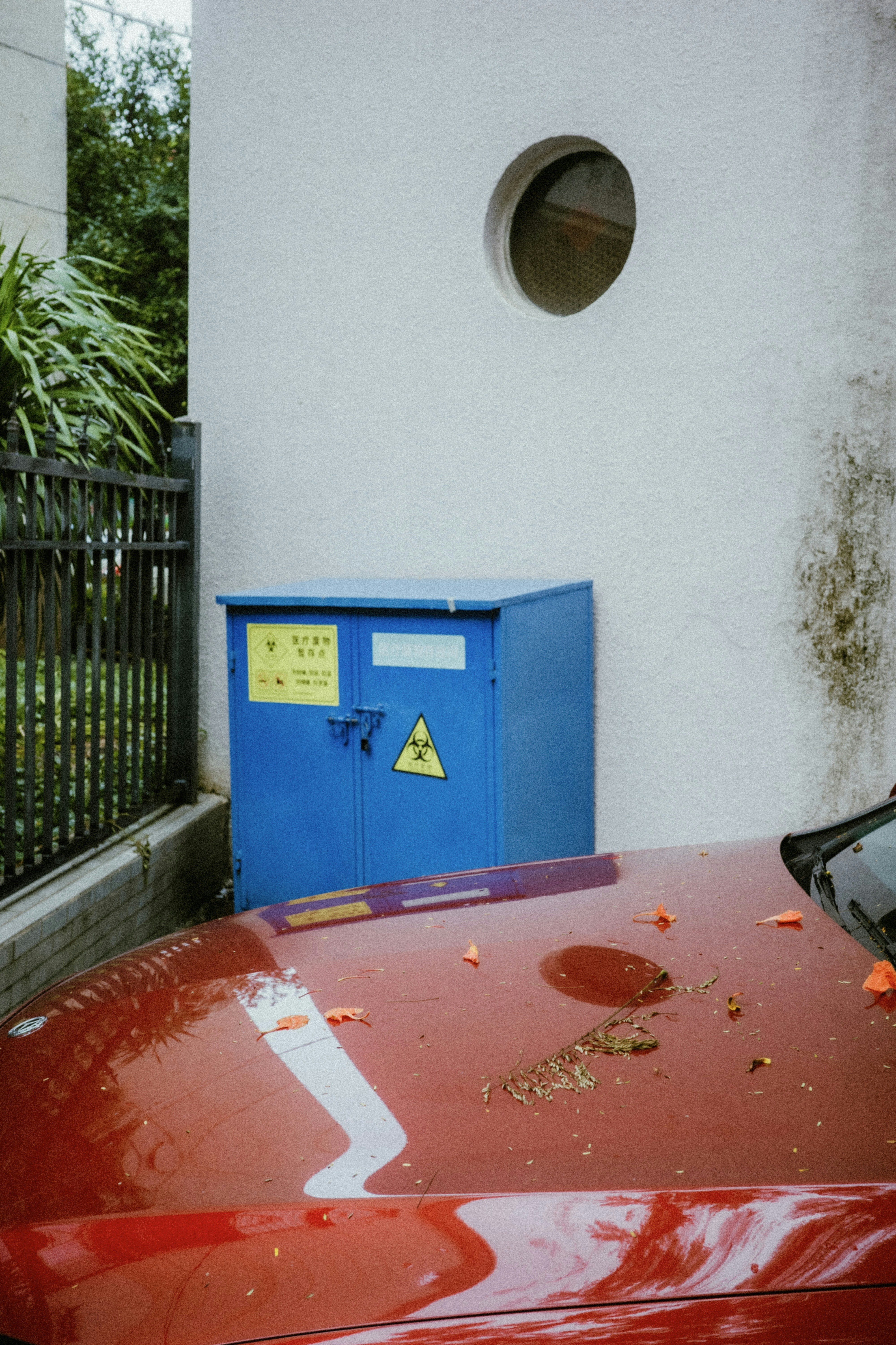 Blue utility box with radiation symbol next to red car