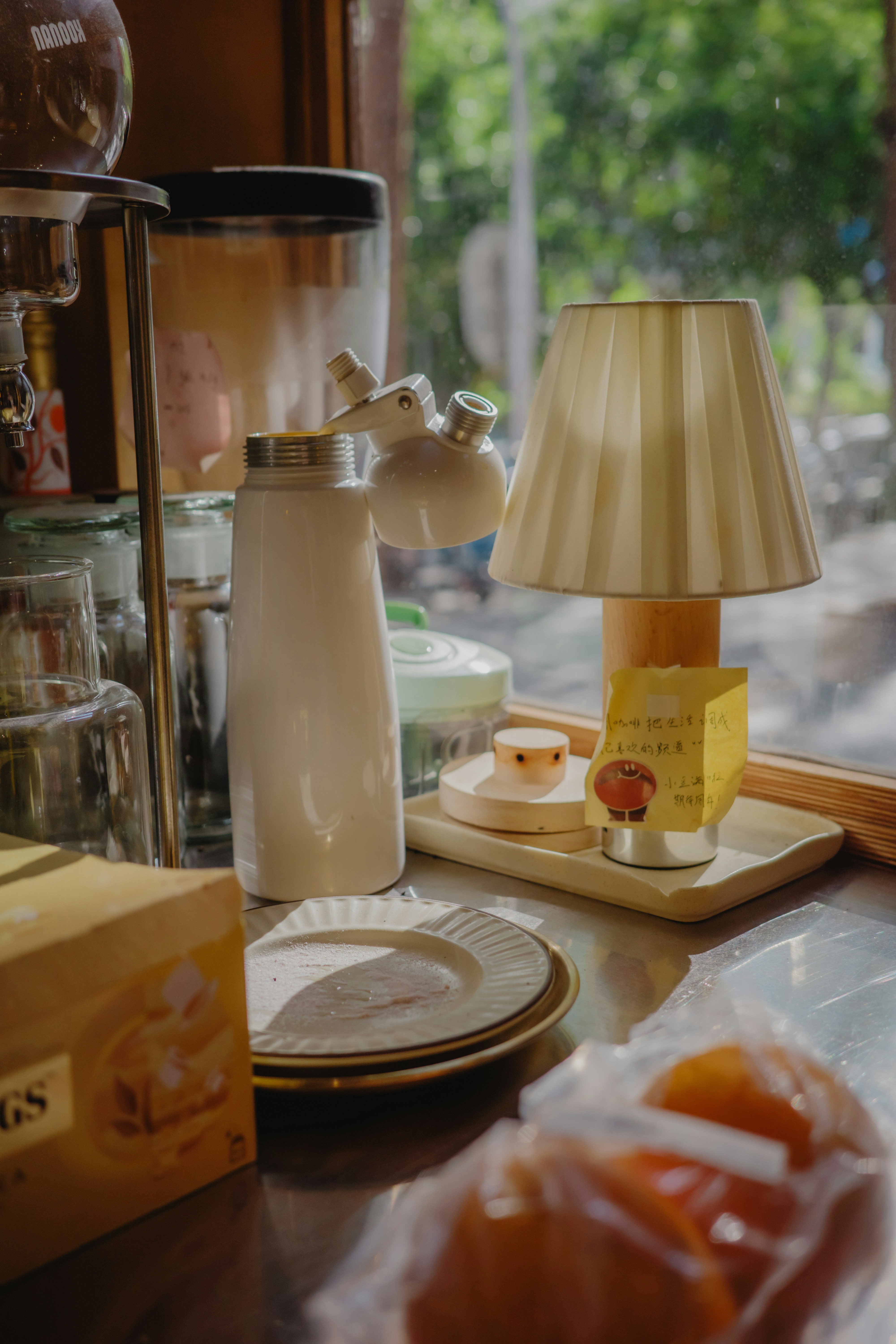 A small lamp and kitchen items on a counter.