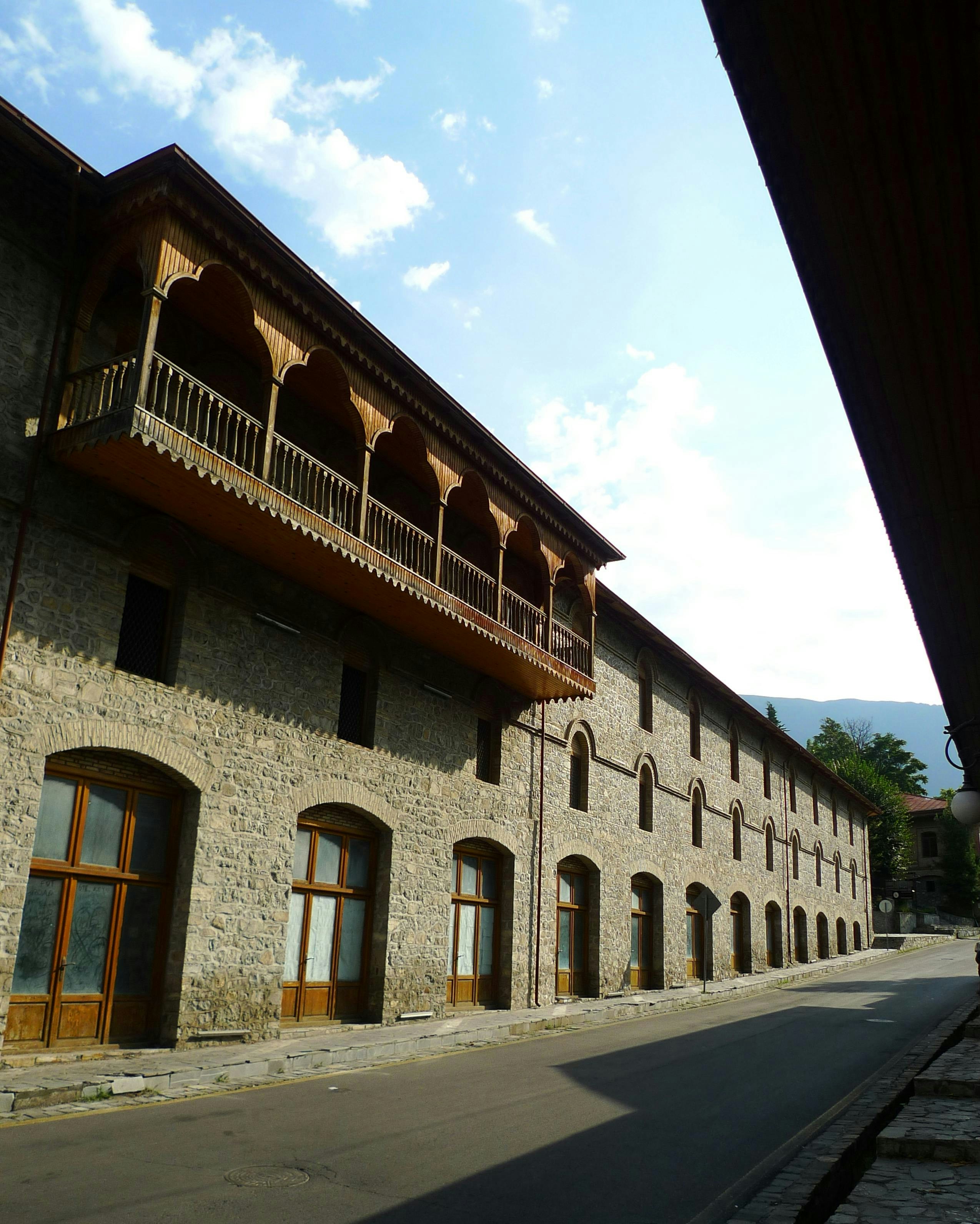 Stone building with a wooden balcony and arched windows - Free Photo on ...