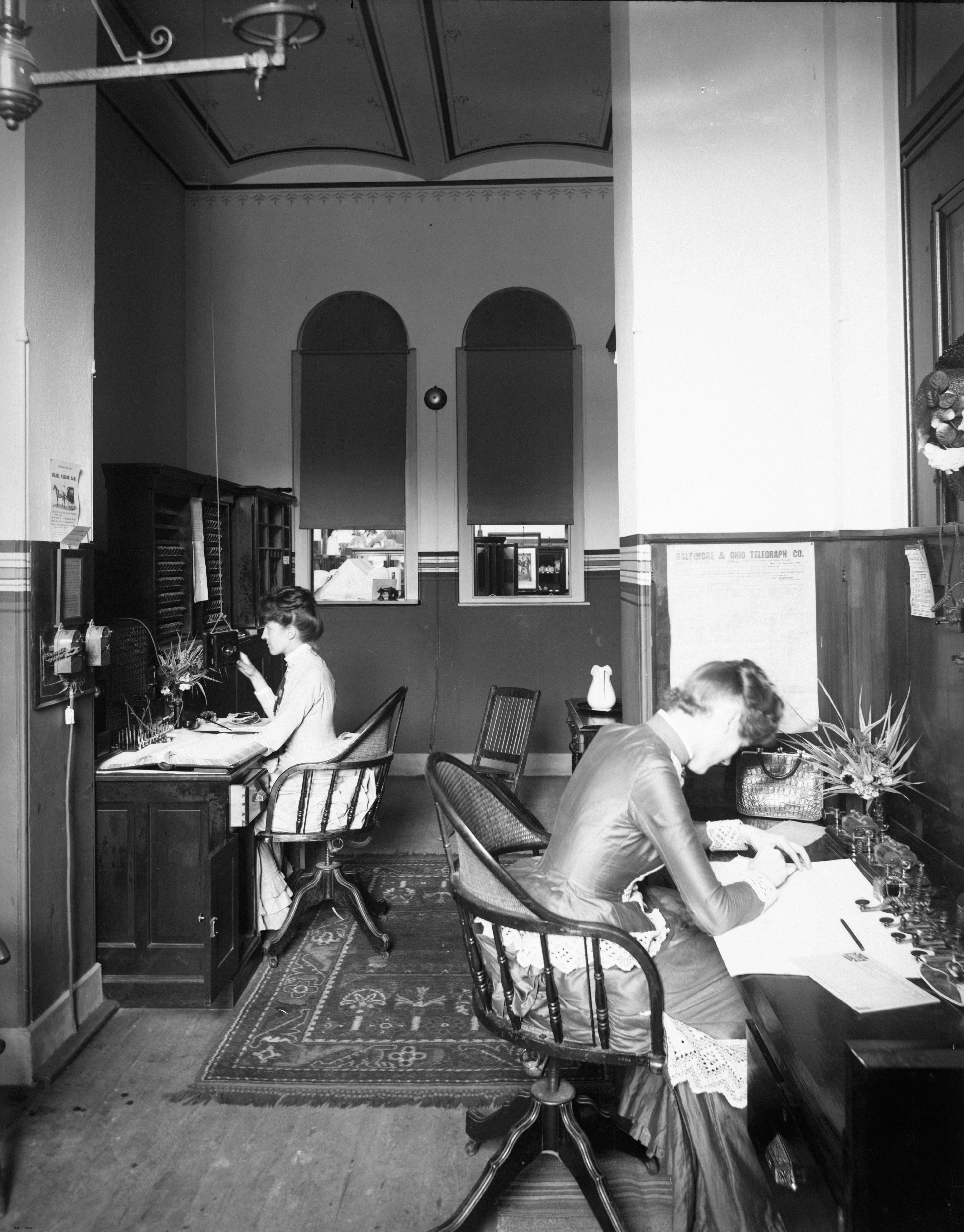 Two women work at desks in an office.