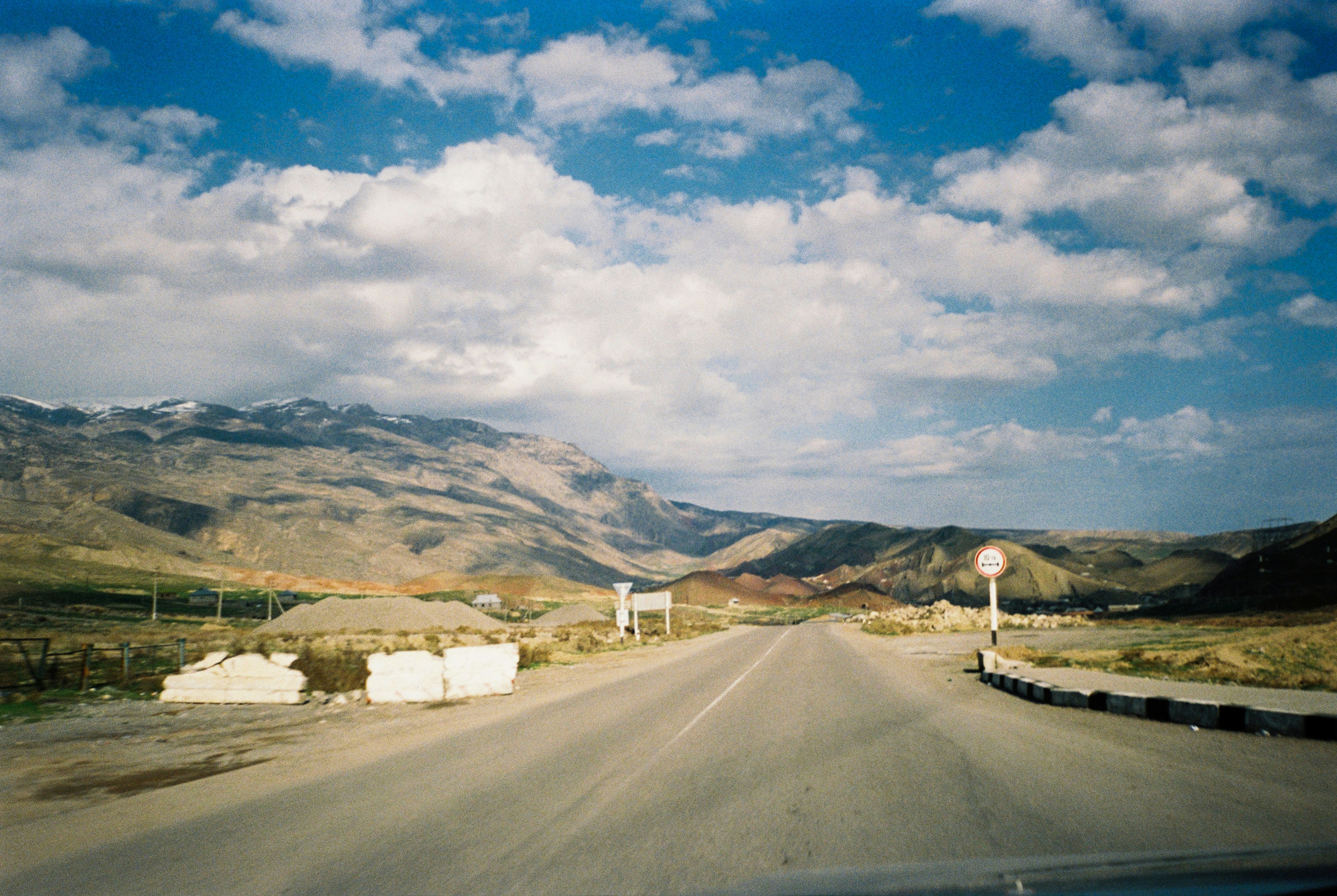 Open road leading to distant mountains under a cloudy sky (Photo by Damir Semirkhanov on Unsplash)