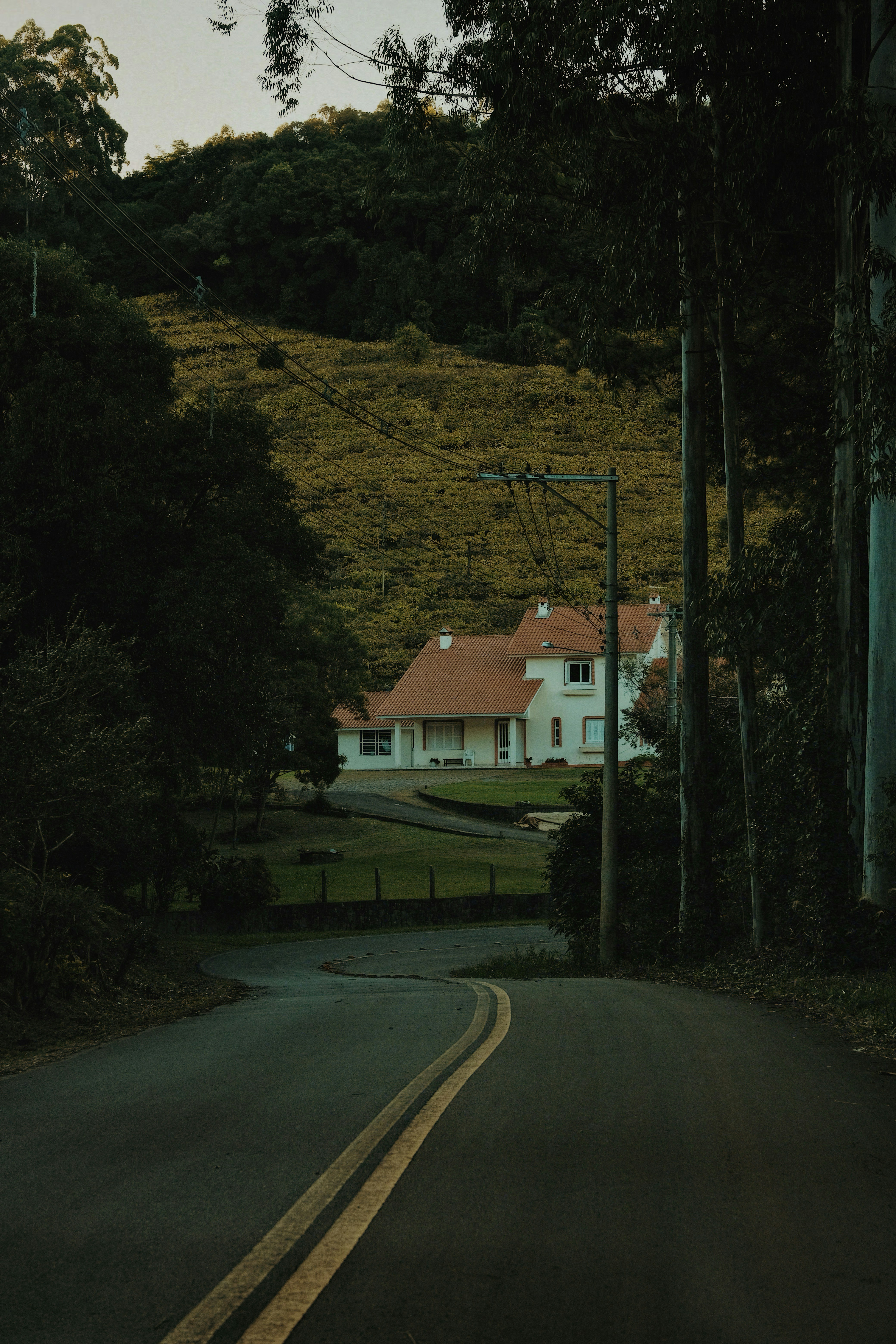 Une maison blanche au toit rouge sur une colline.