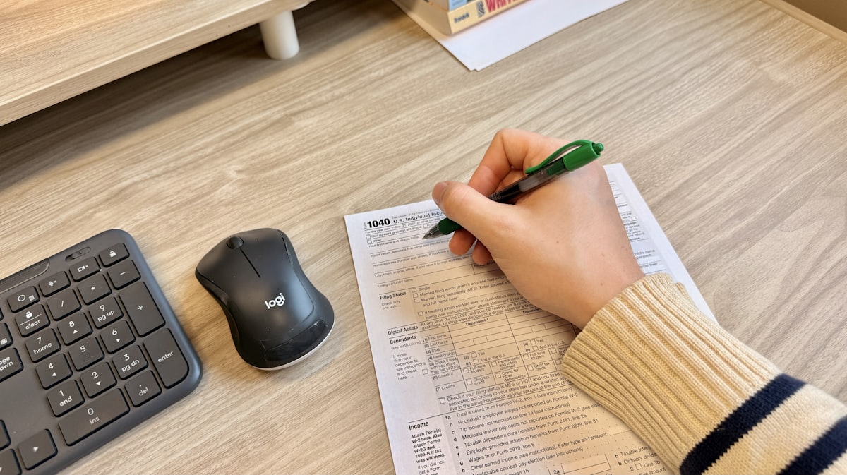 Paralegal marking up a legal contract by hand next to a keyboard while using AI contract review tools