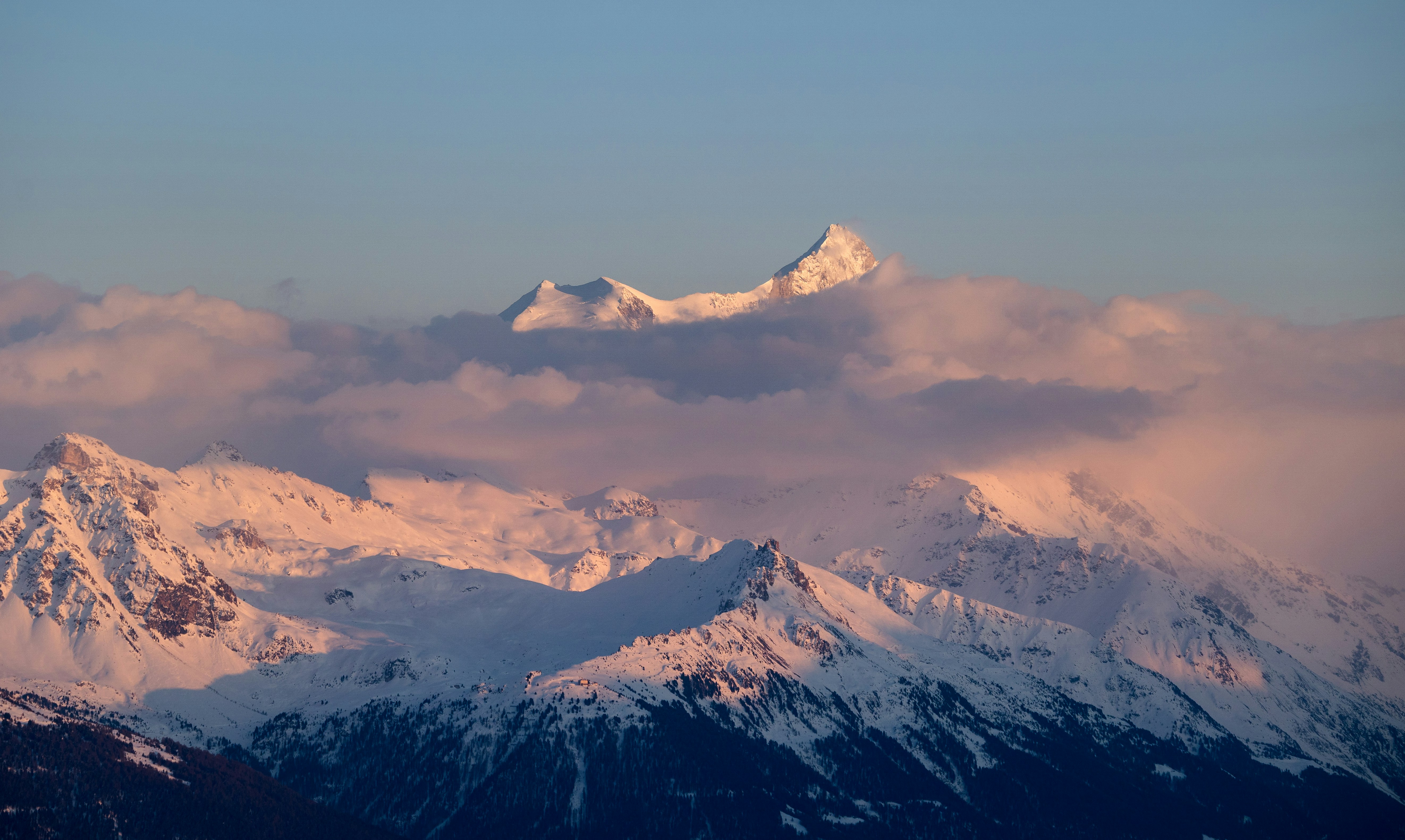 Montagne innevate illuminate dalla luce dorata del tramonto