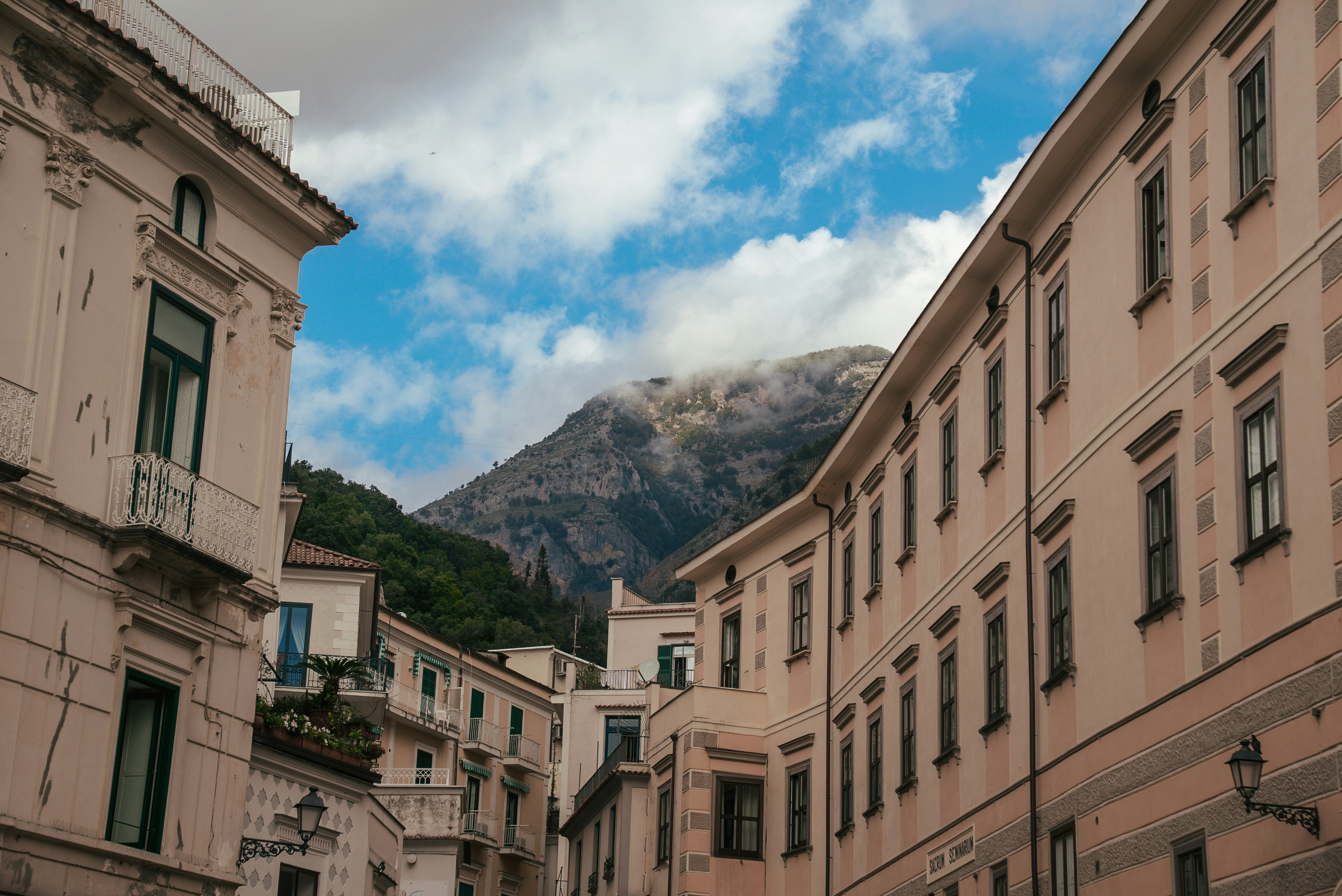 Street lined with old buildings and a cloudy mountain.