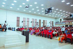 Audience seated in a large hall with a stage