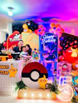 Family poses at a vibrant pokémon-themed birthday party