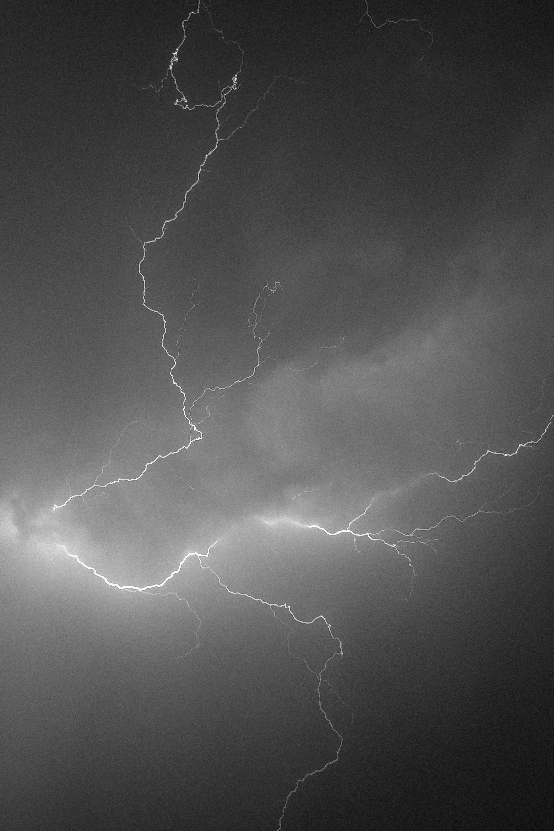 Fulmini brillanti colpiscono un cielo scuro e tempestoso.