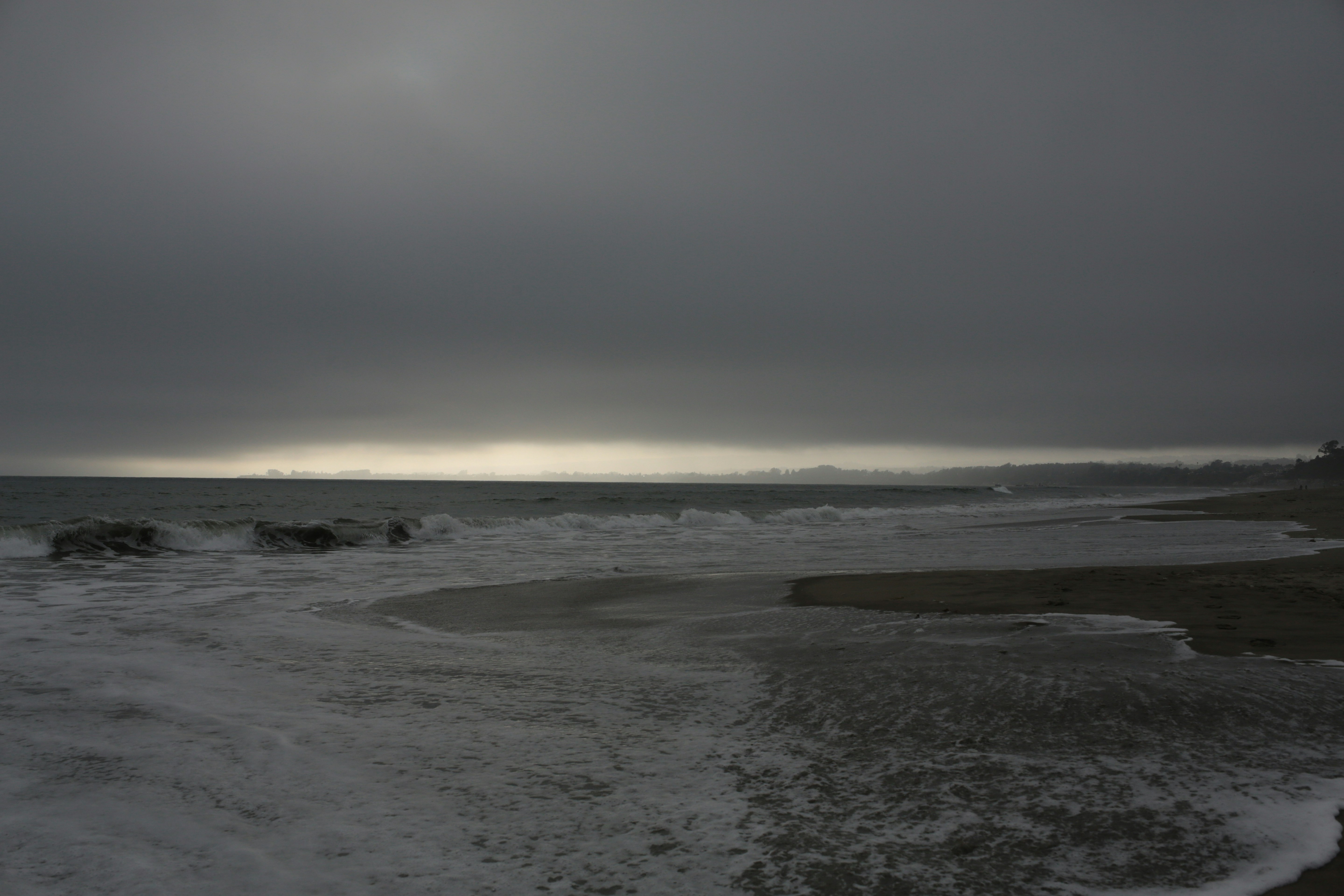 Waves crashing on a rocky shore under a stormy sky