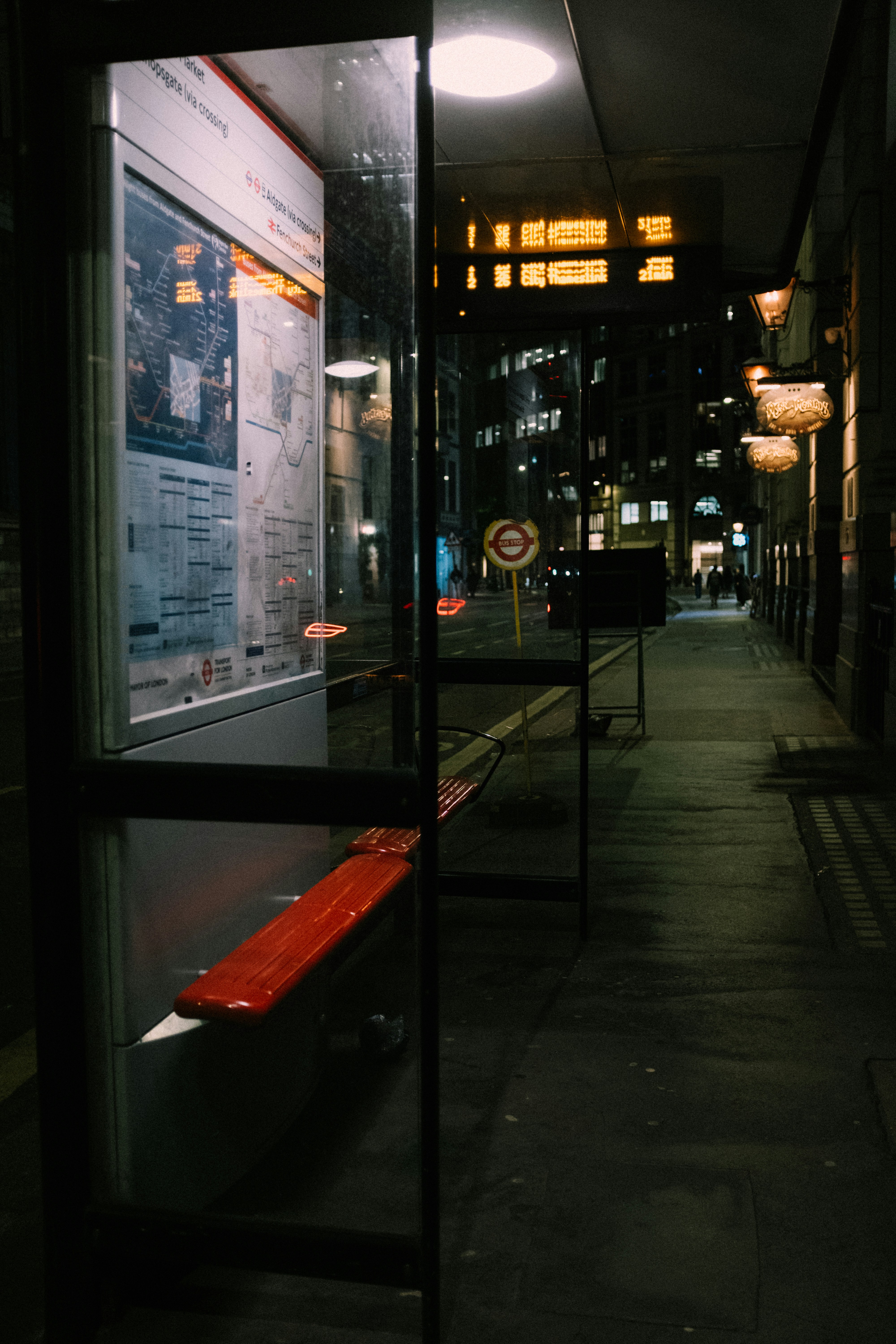 Una parada de autobús por la noche con luces de ciudad