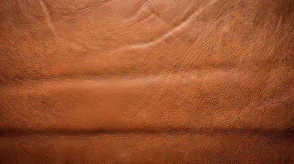 Cuero marrón con grano visible y costura de guarnicionería — el corazón de cuero y jazmín sambac de Ombré Leather, por la perfumería Olara