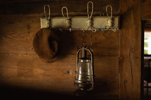 Hat and lantern on a rustic wall