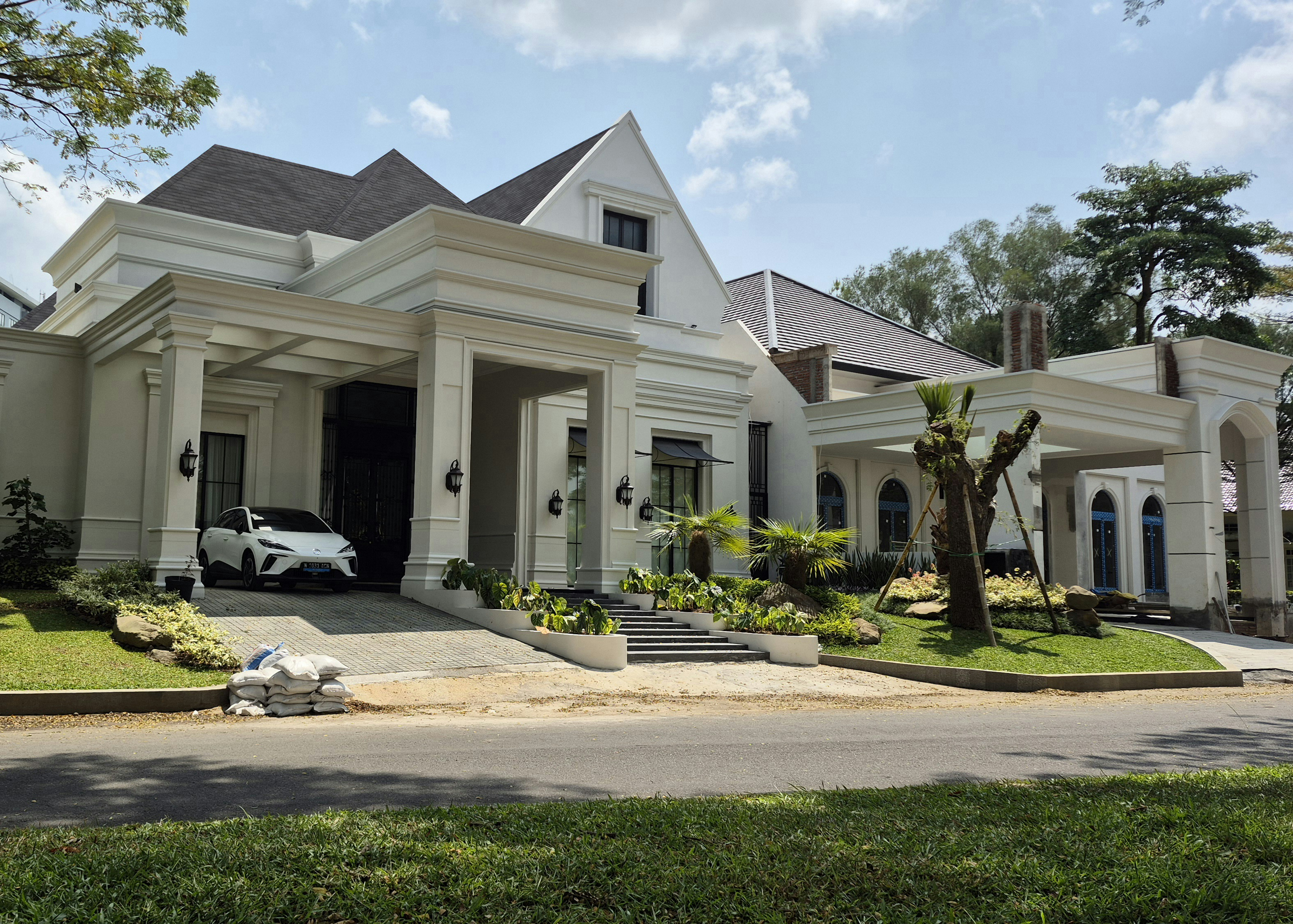 Una gran casa blanca moderna con un coche.