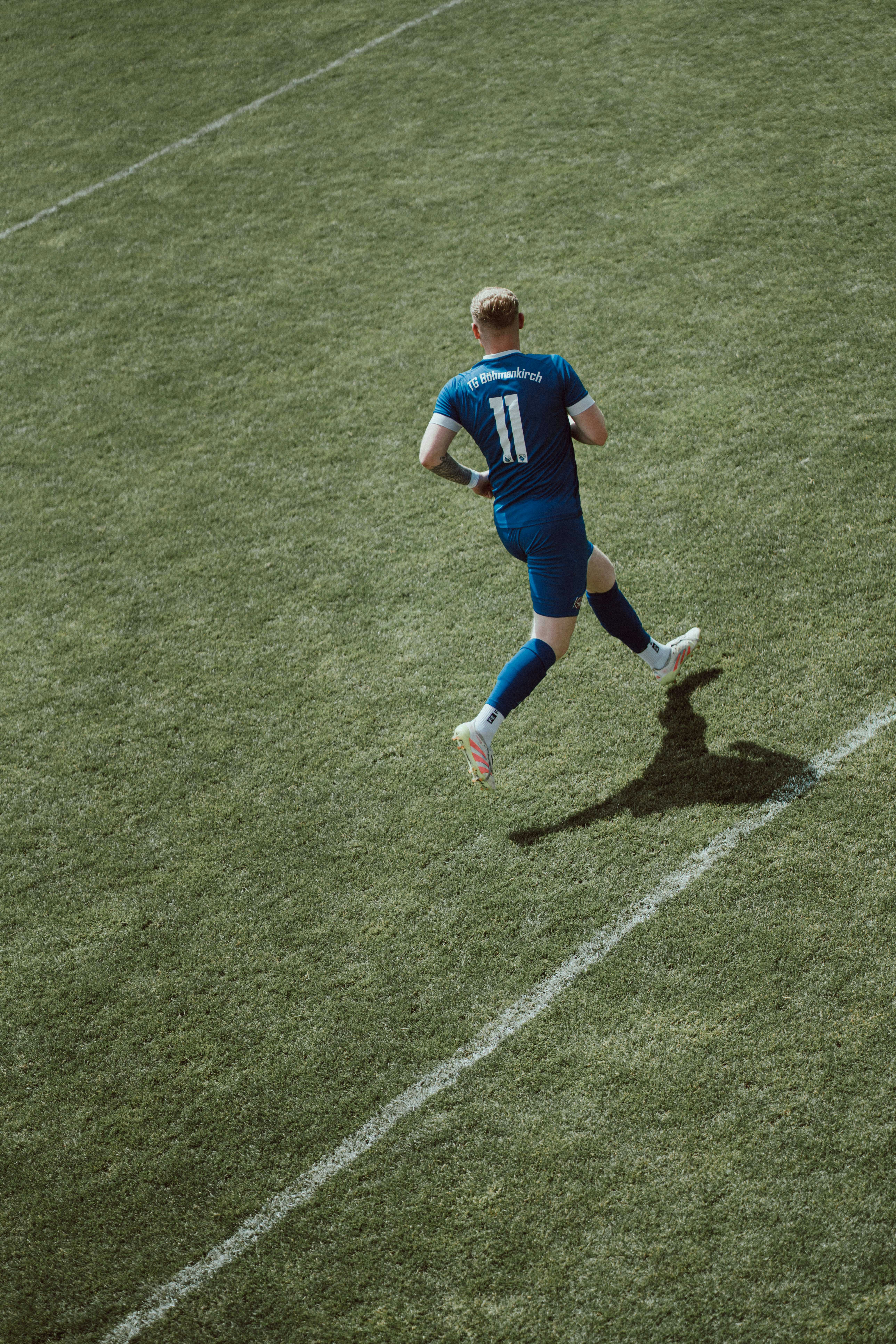 Soccer player in blue uniform running on field