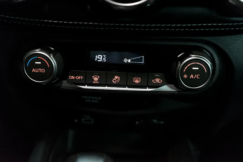 Car climate control panel showing the A/C button and temperature display