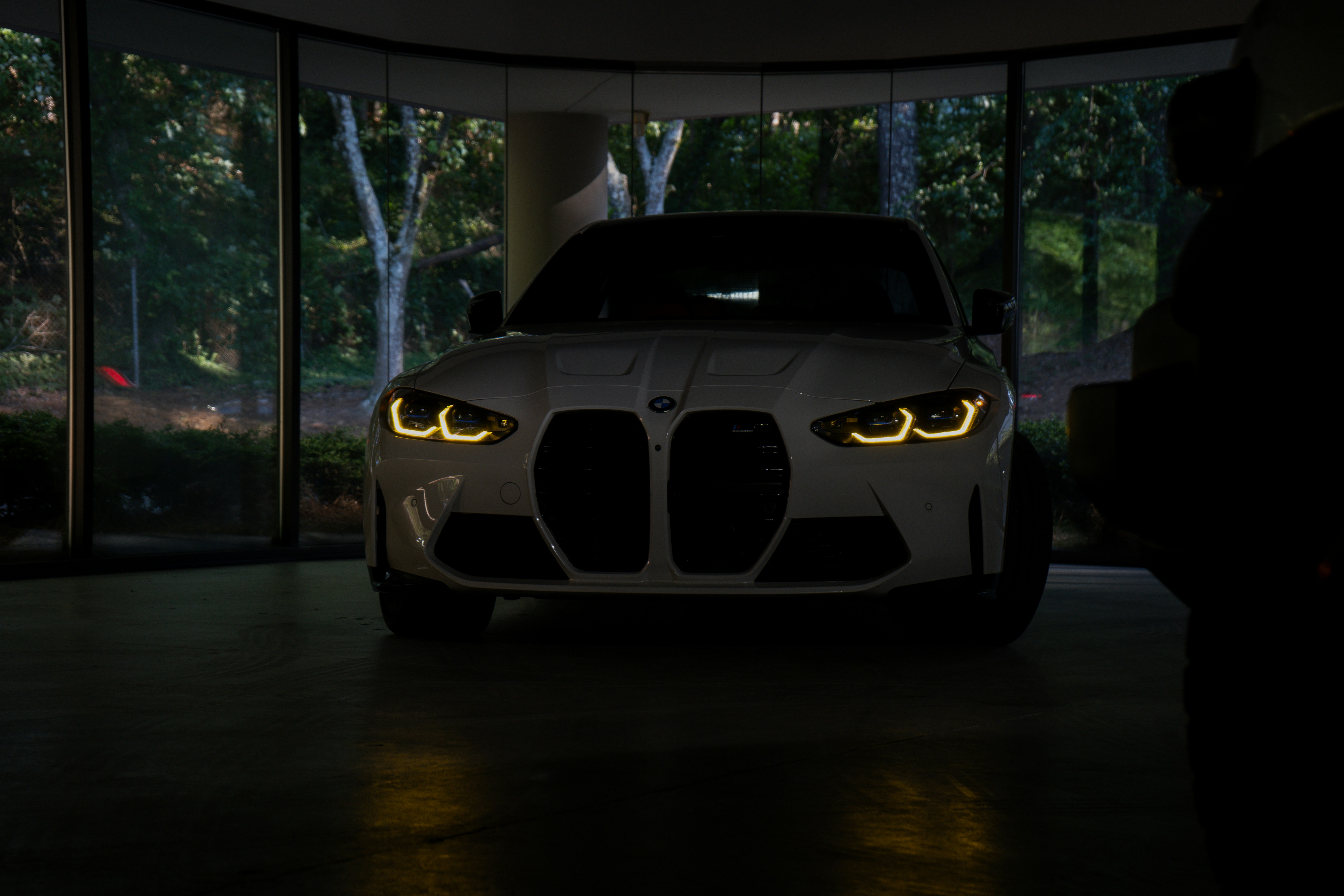 夜の最新のガレージに駐車されている白いBMW M3。