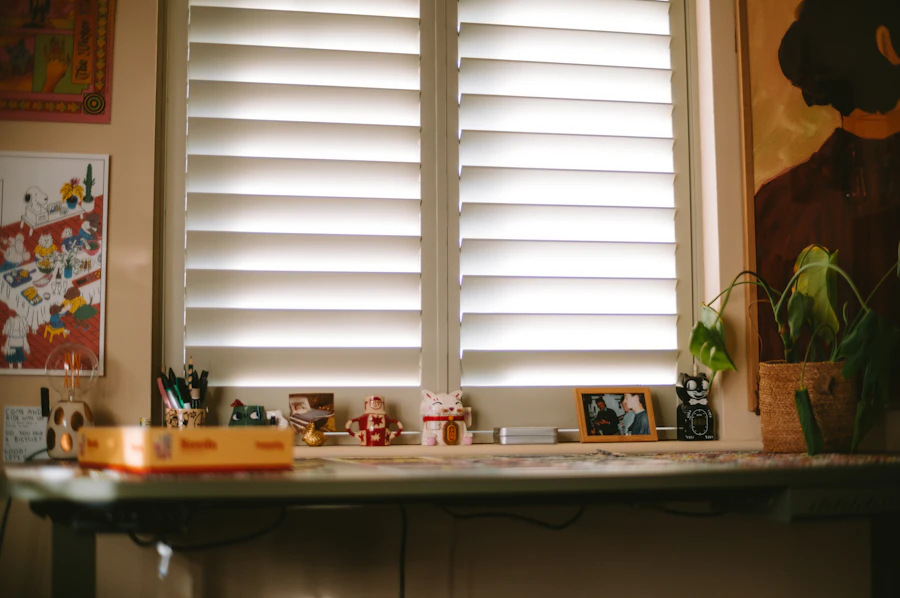 Home workspace desk beside a window fitted with plantation shutters