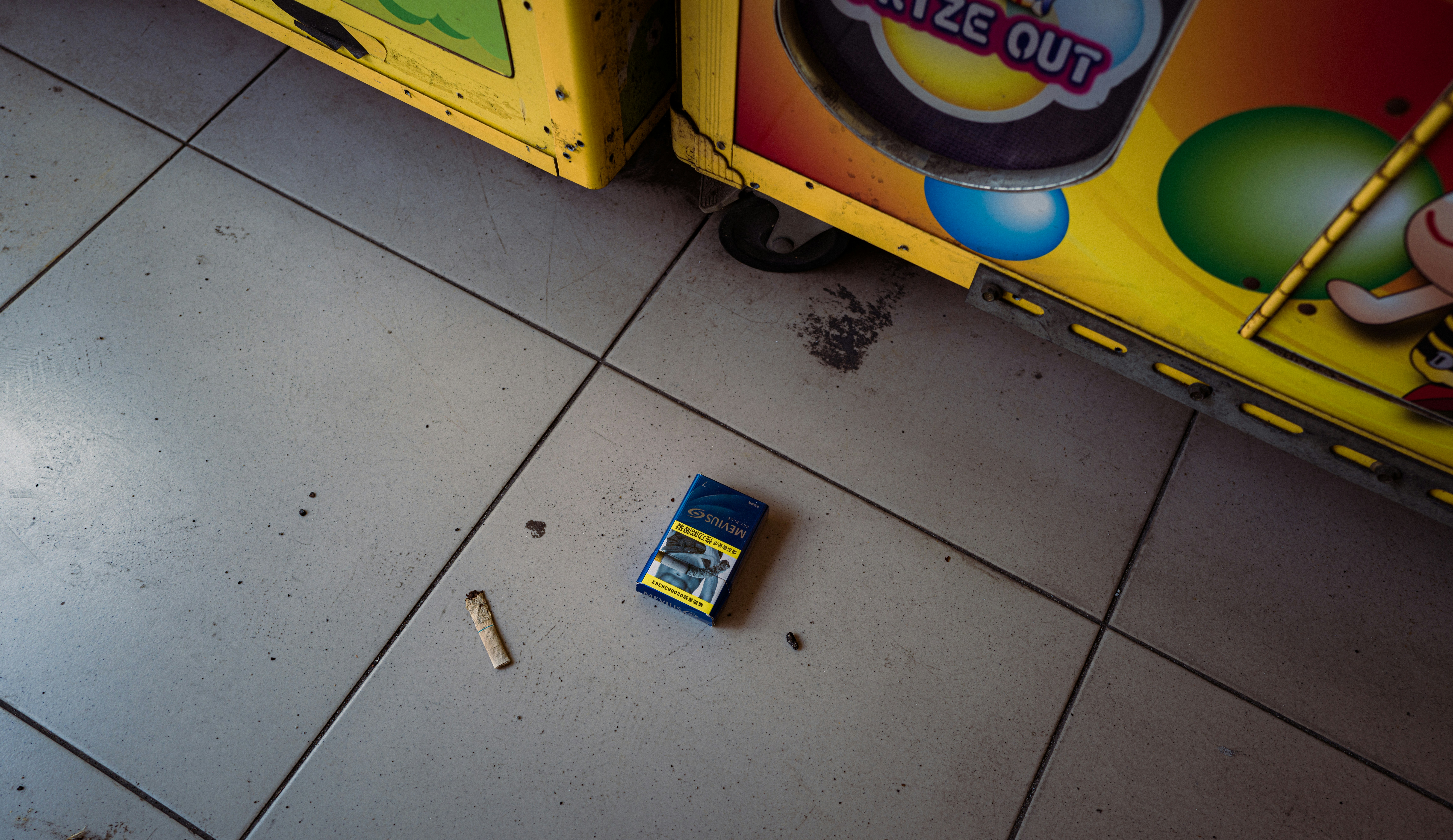Cigarette pack and butt on tiled floor