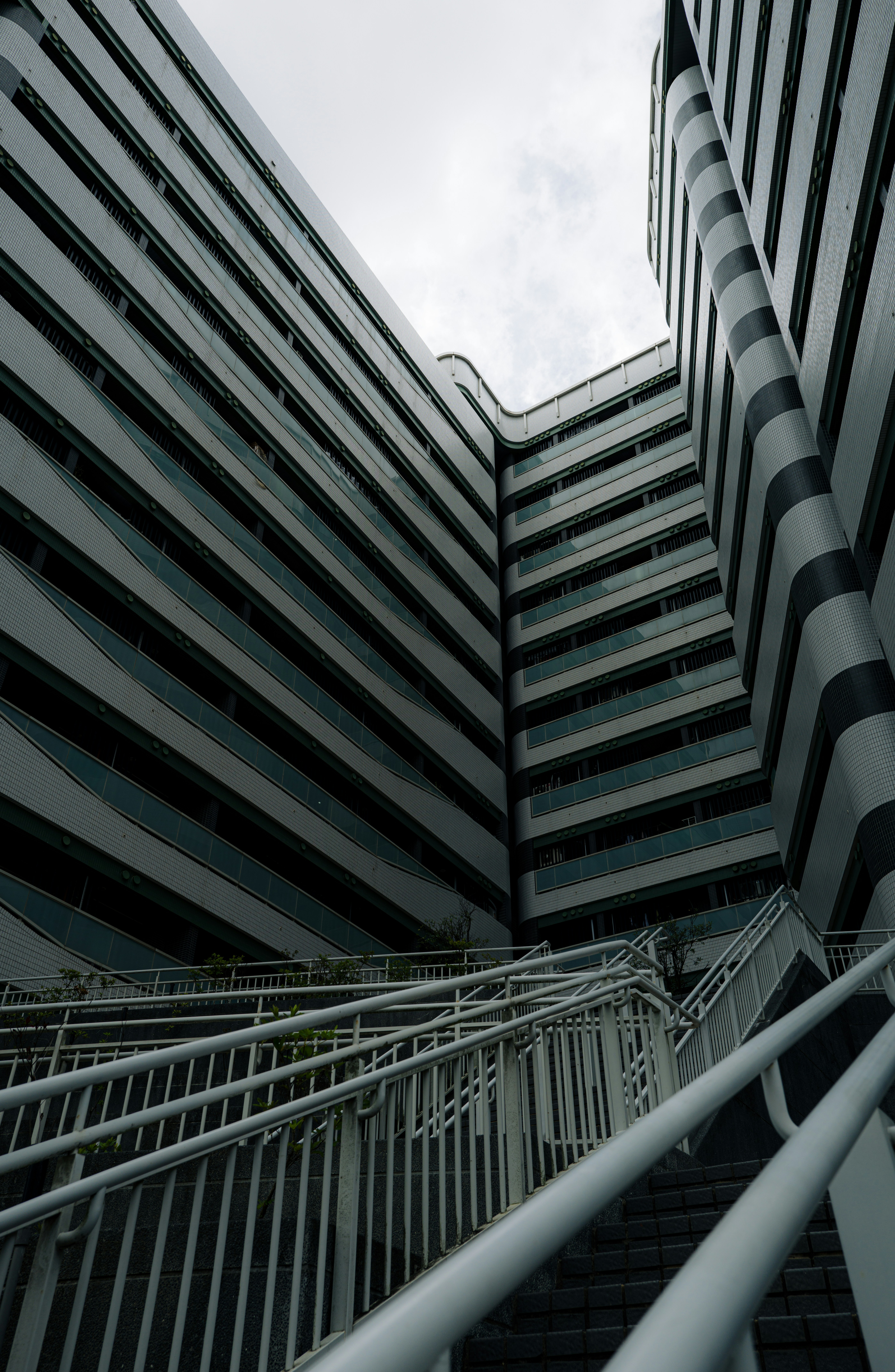 Geometric building architecture with a white railing staircase.
