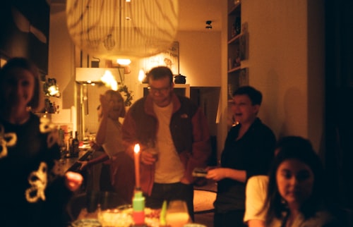 Friends gathered round a table with a lit candle