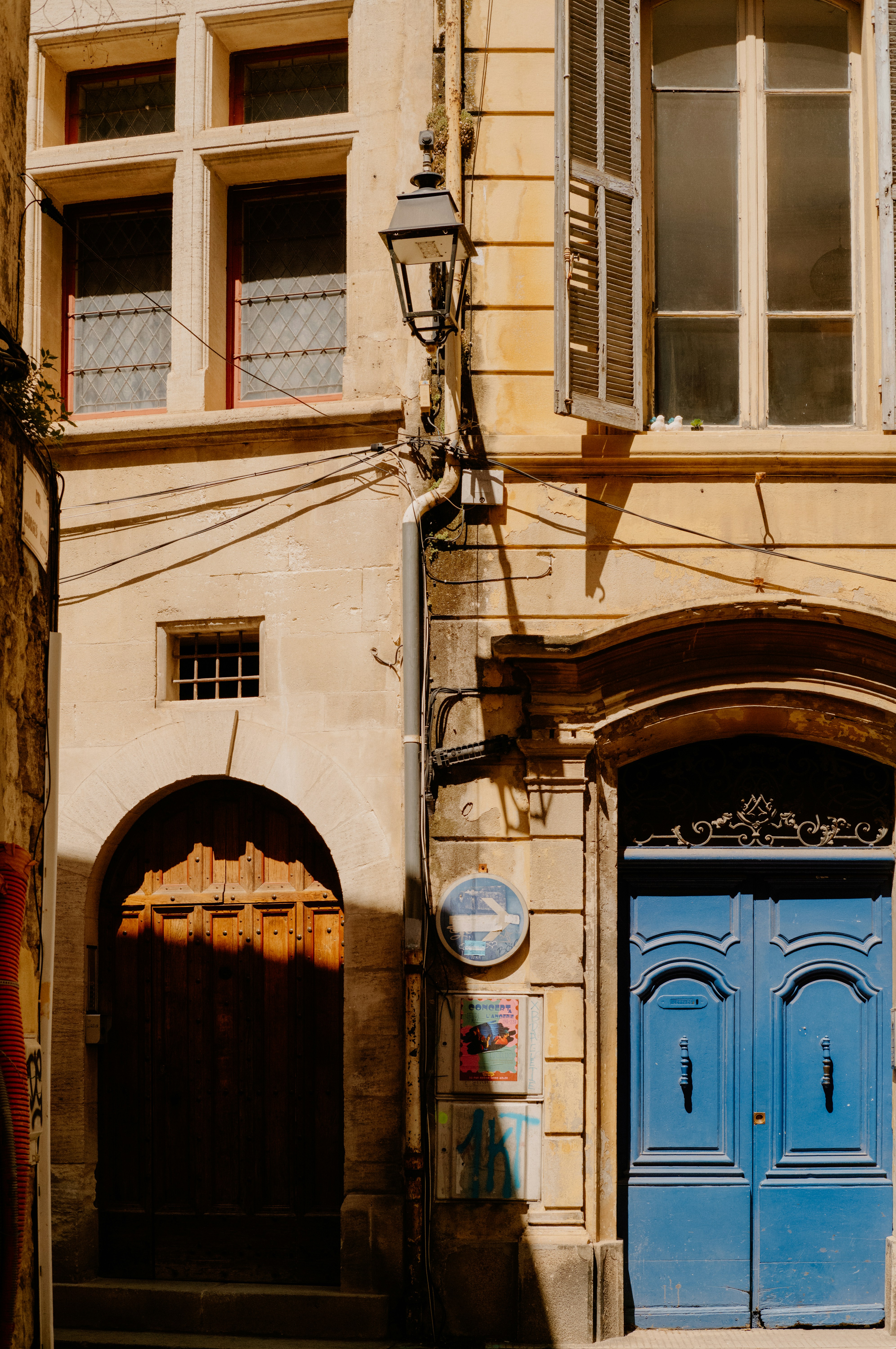Old building facade with wooden and blue doors.