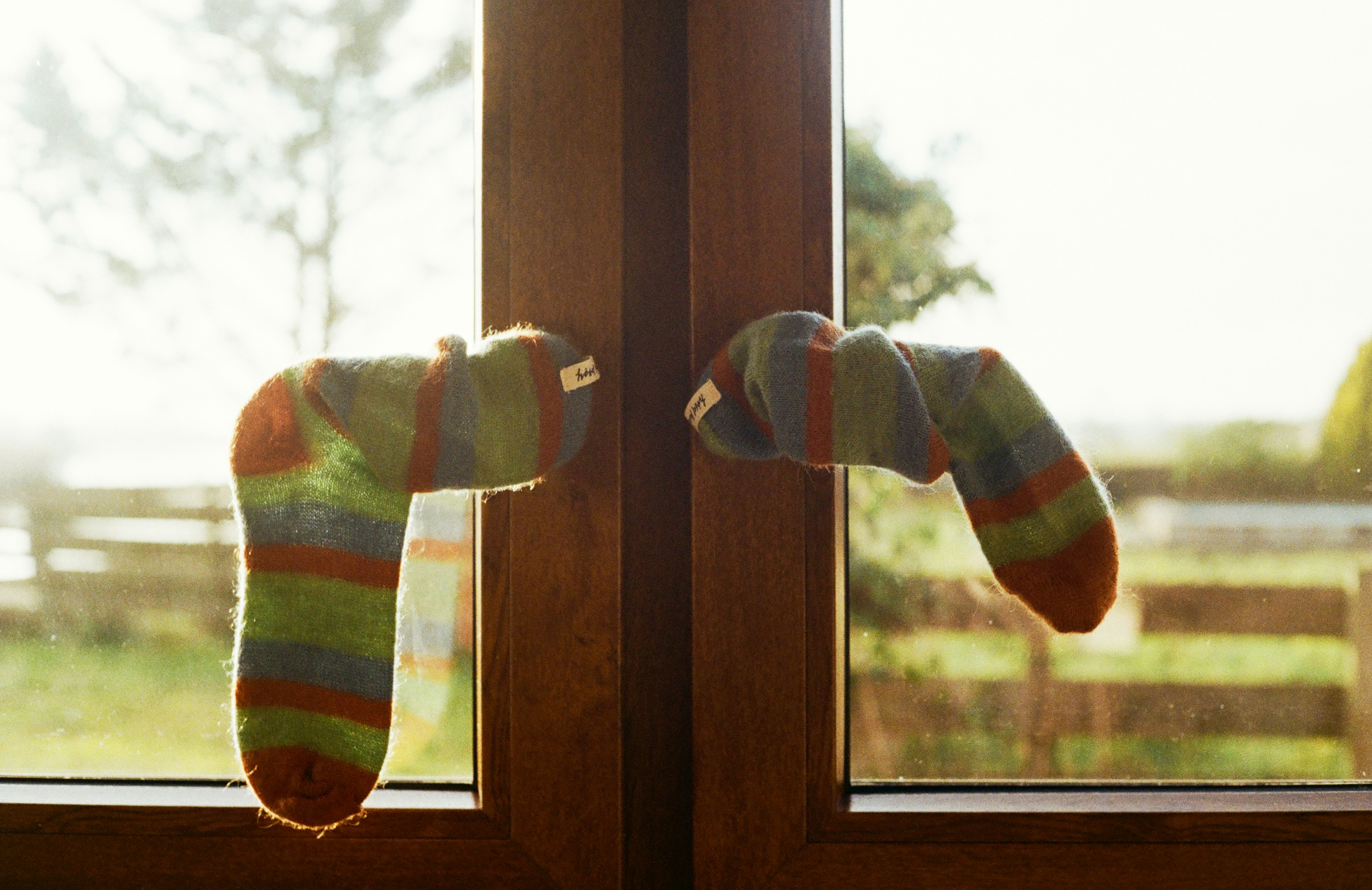 Striped socks hanging on a wooden door handle.