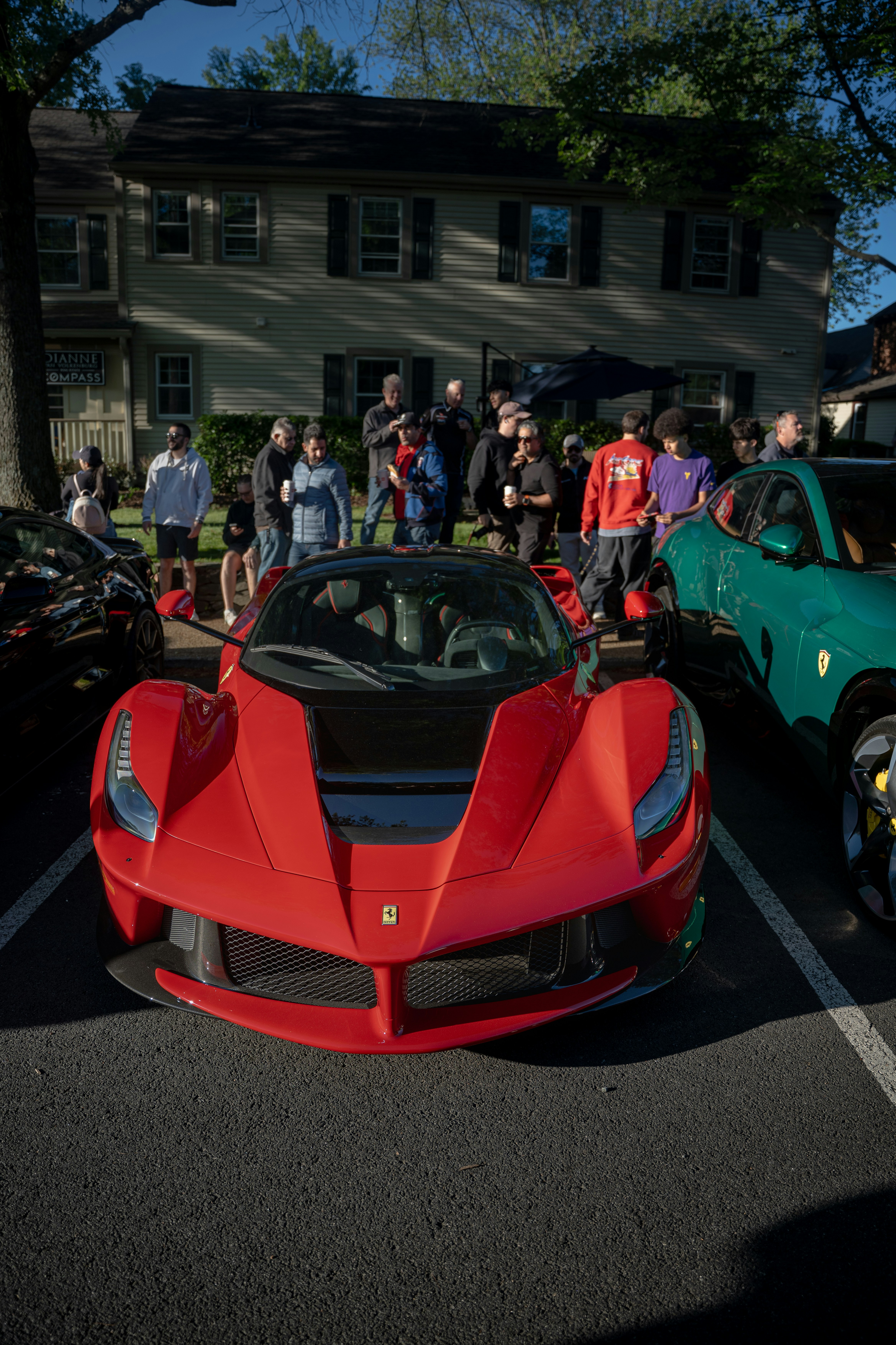 A sleek red sports car displayed outdoors among spectators