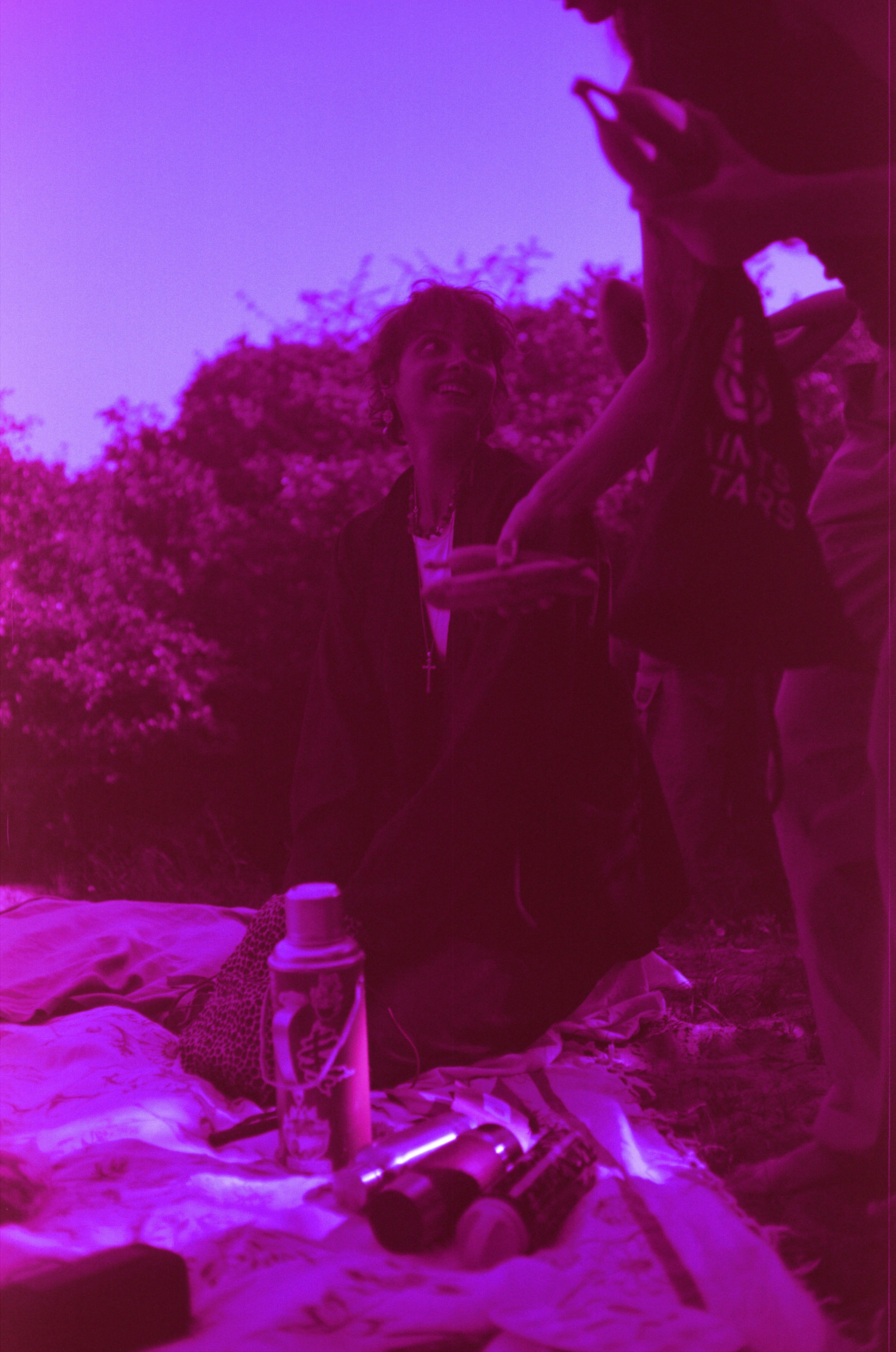 Friends gathered outdoors with drinks at dusk.
