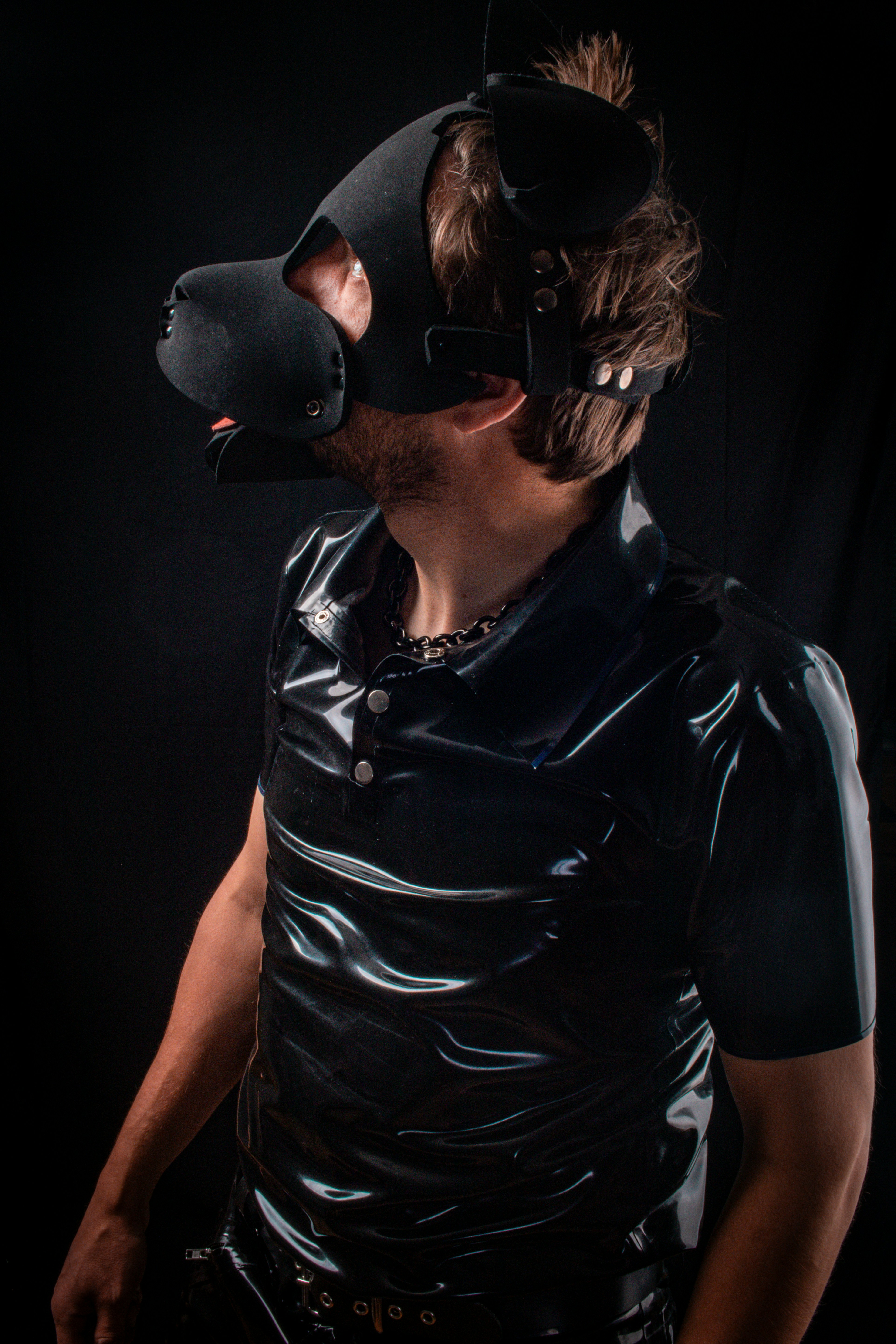 Personne en t-shirt en latex noir et capuchon de chiot.