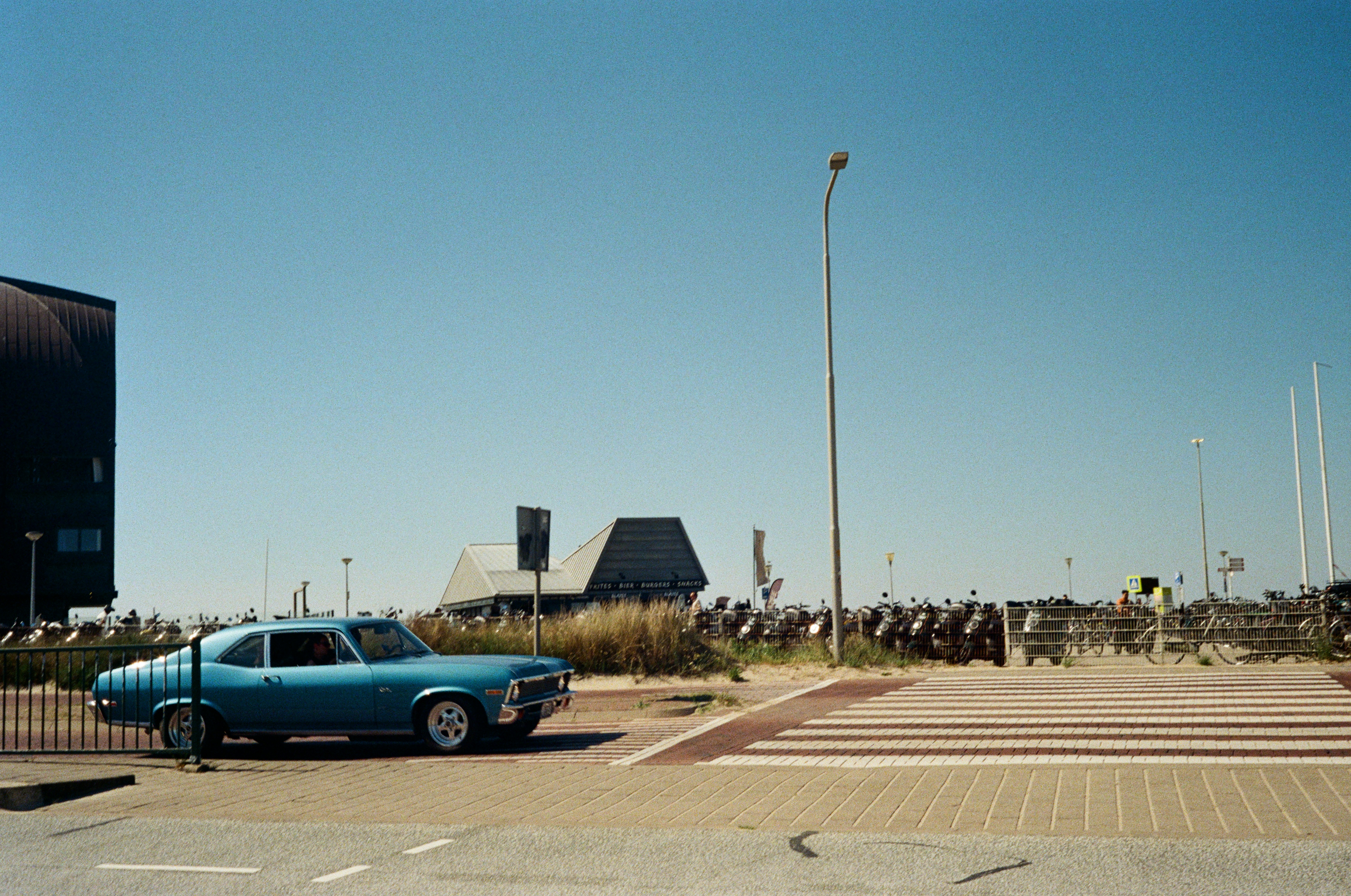 A blue vintage car parked near a building.