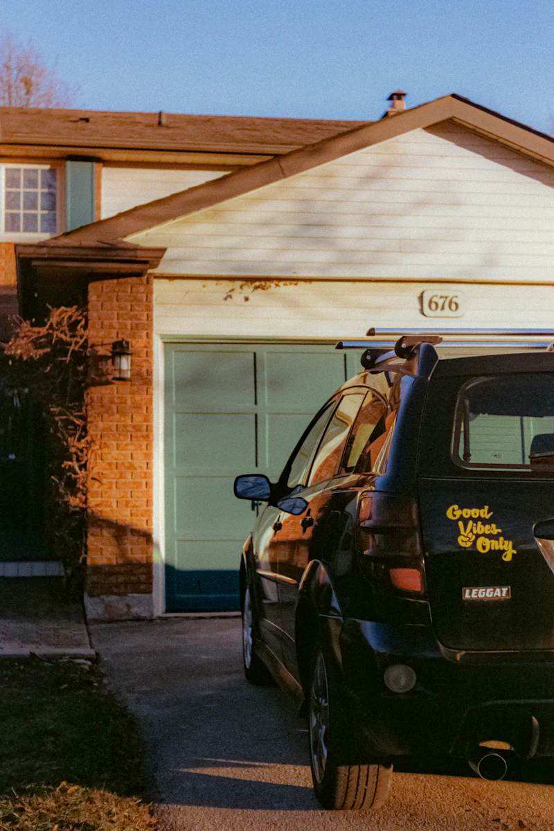 Black car parked in front of a suburban house