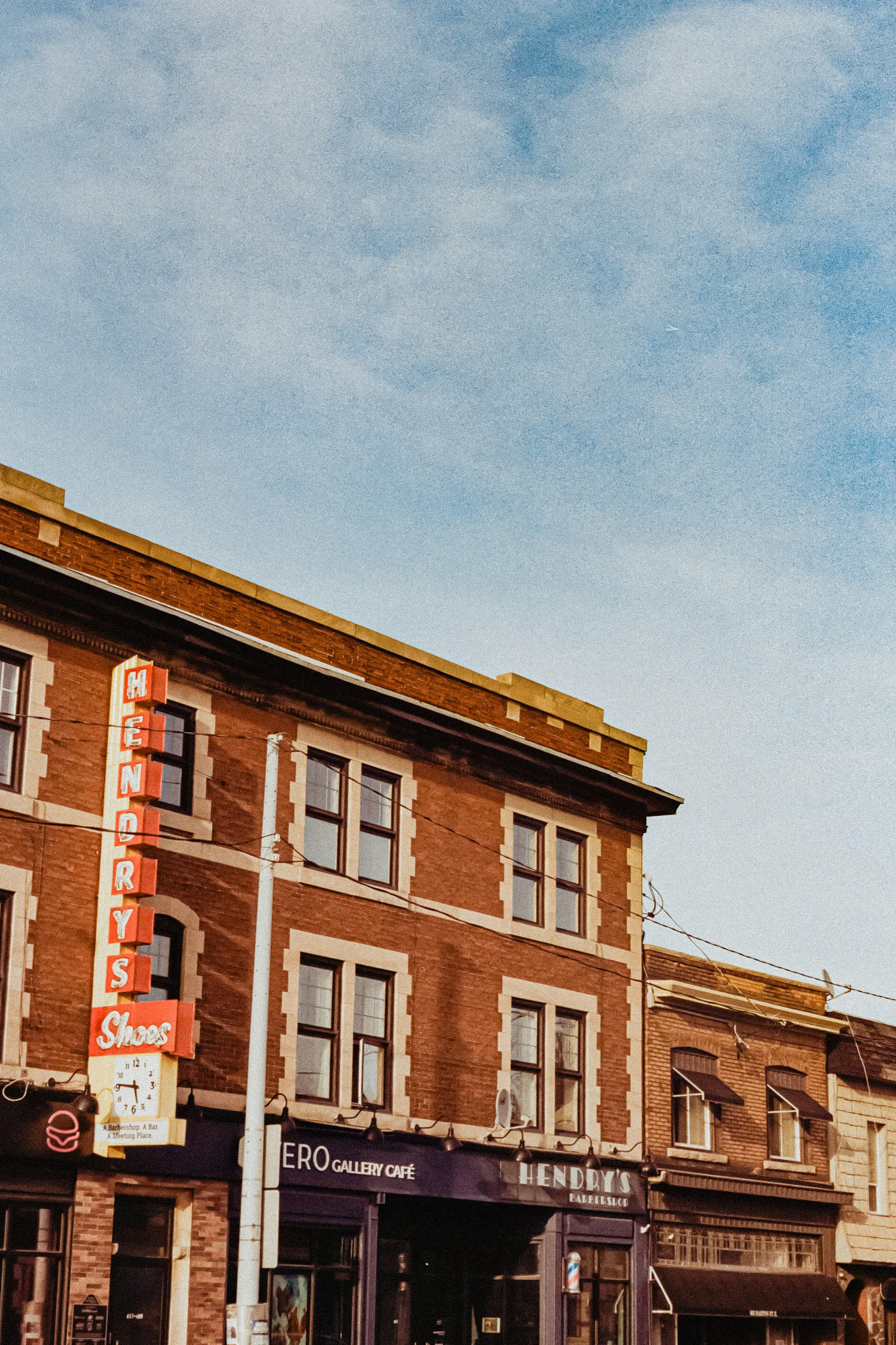 Row of brick storefronts with neon signs